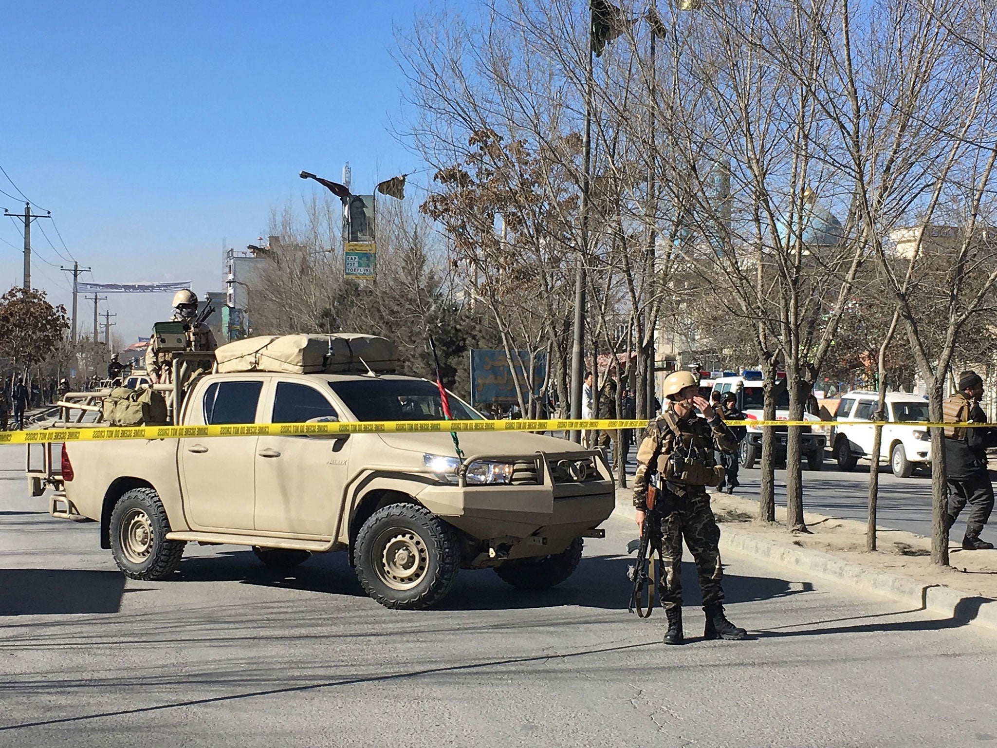 Afghan security forces stand guard near the site of previous blasts in Kabul on 28 December