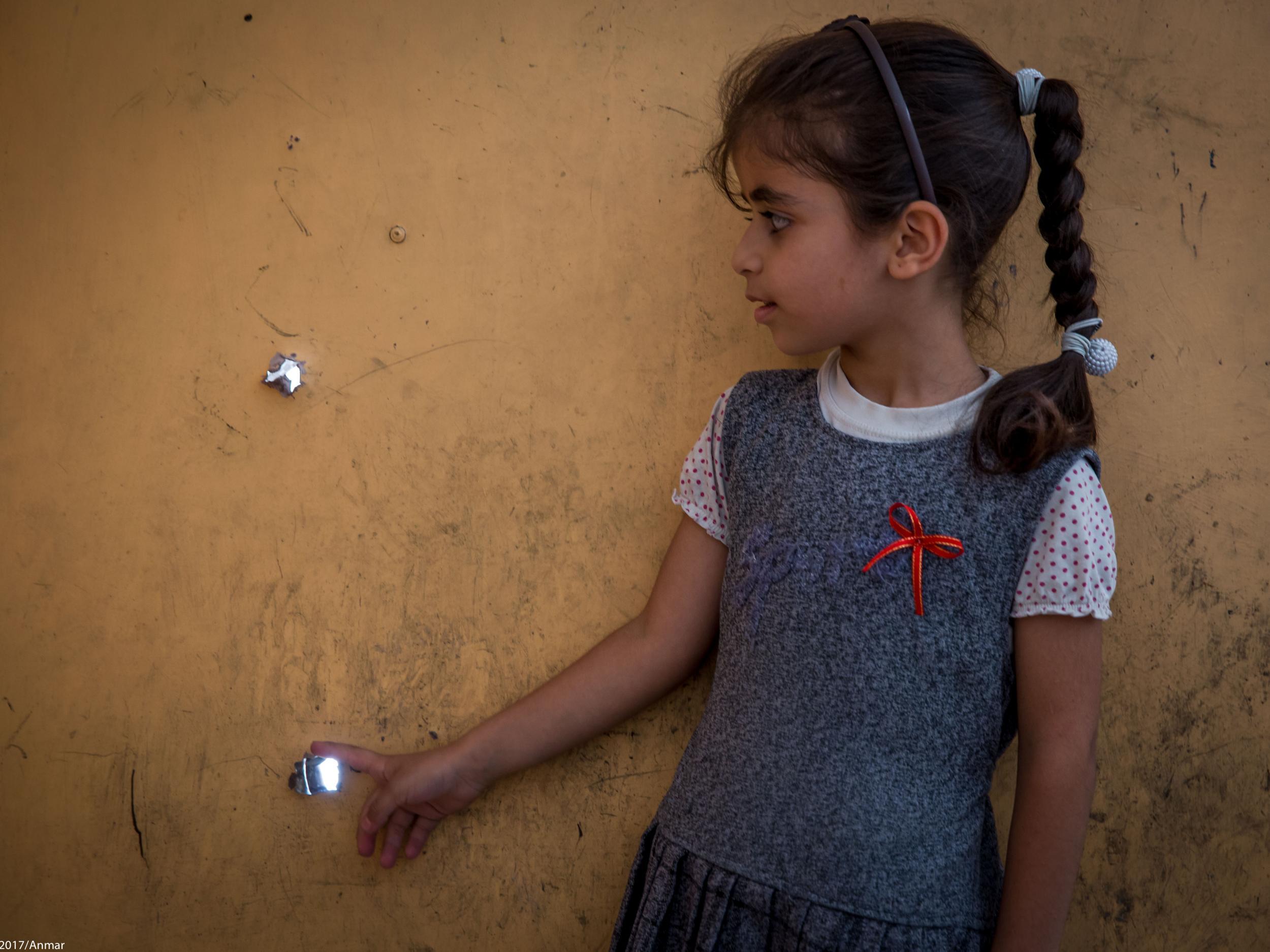 'Our house has these too,' Abrar said as she points to the bullet holes in the door of Farahedee School in Iraq