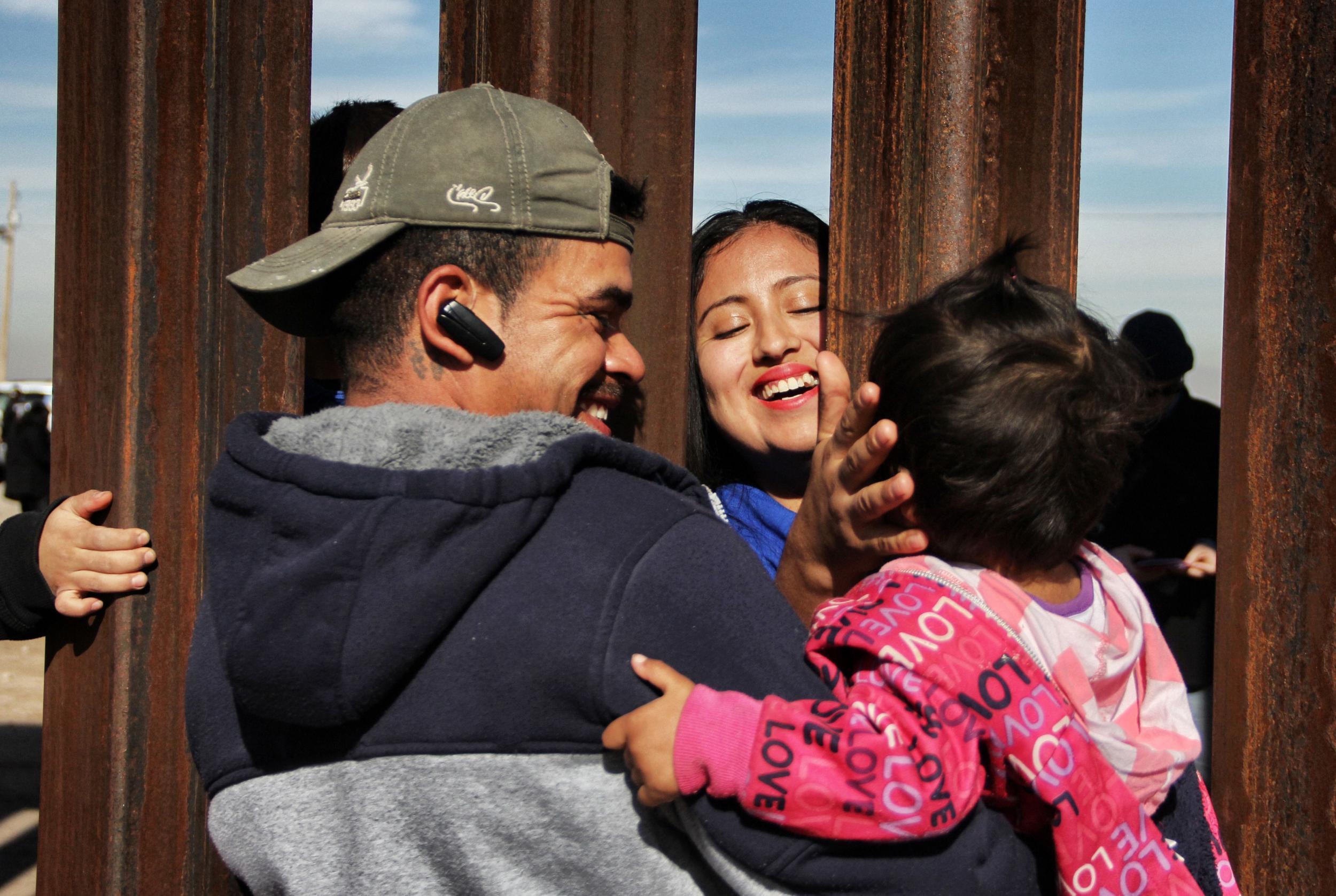 Members of a family reunite through the border wall between Mexico and United States