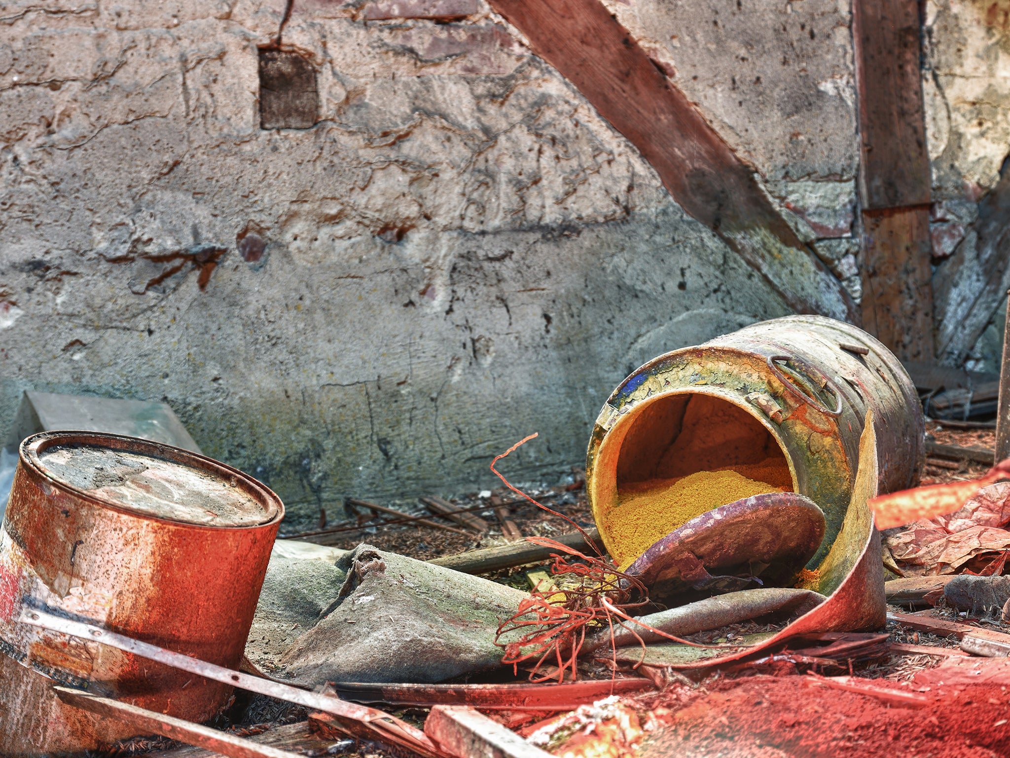 A barrel full of chemical waste lies where a textile factory was demolished