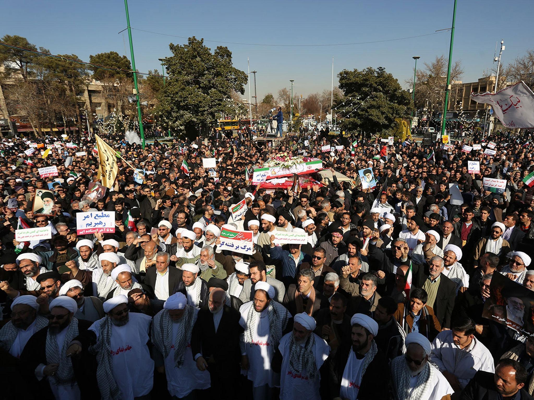 Pro-government demonstrators hold banners during a march in the central Iranian city of Isfahan