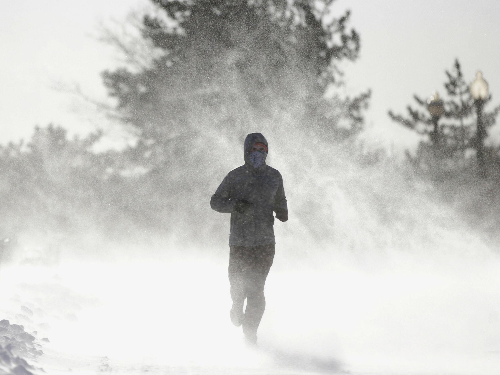 Gusty wind picks up snow as a man jogs around Liberty State Park in Jersey City