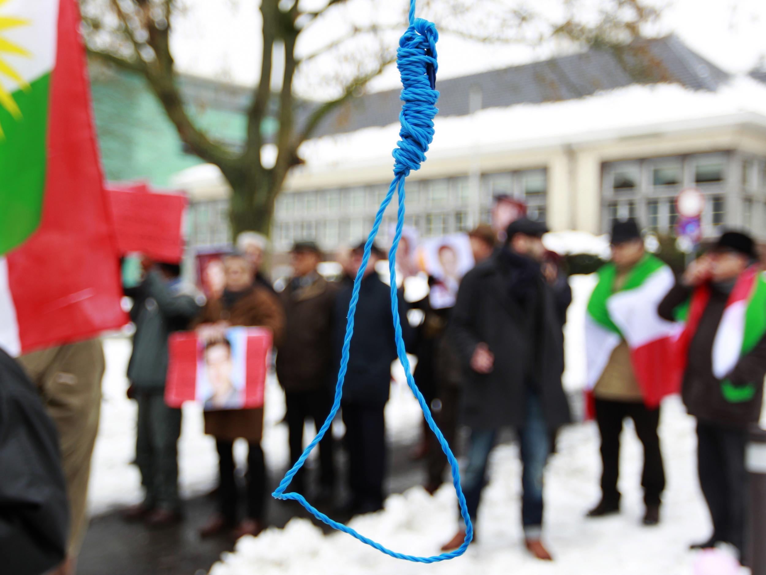 Iranian exiles shout slogans in front of a mock gallows during a demonstration in Brussels in 2010