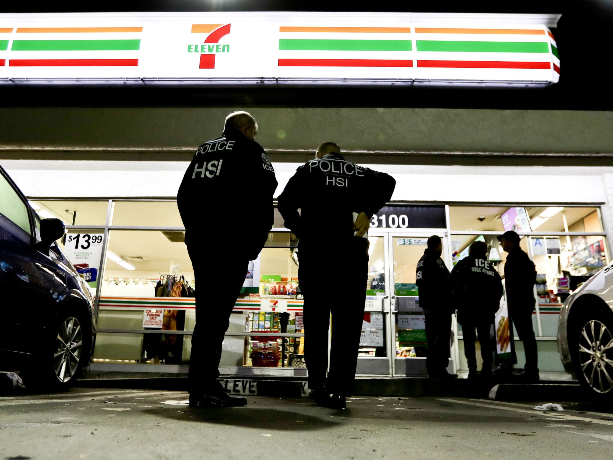 US Immigration and Customs Enforcement agents serve an employment audit notice at a 7-Eleven in Los Angeles
