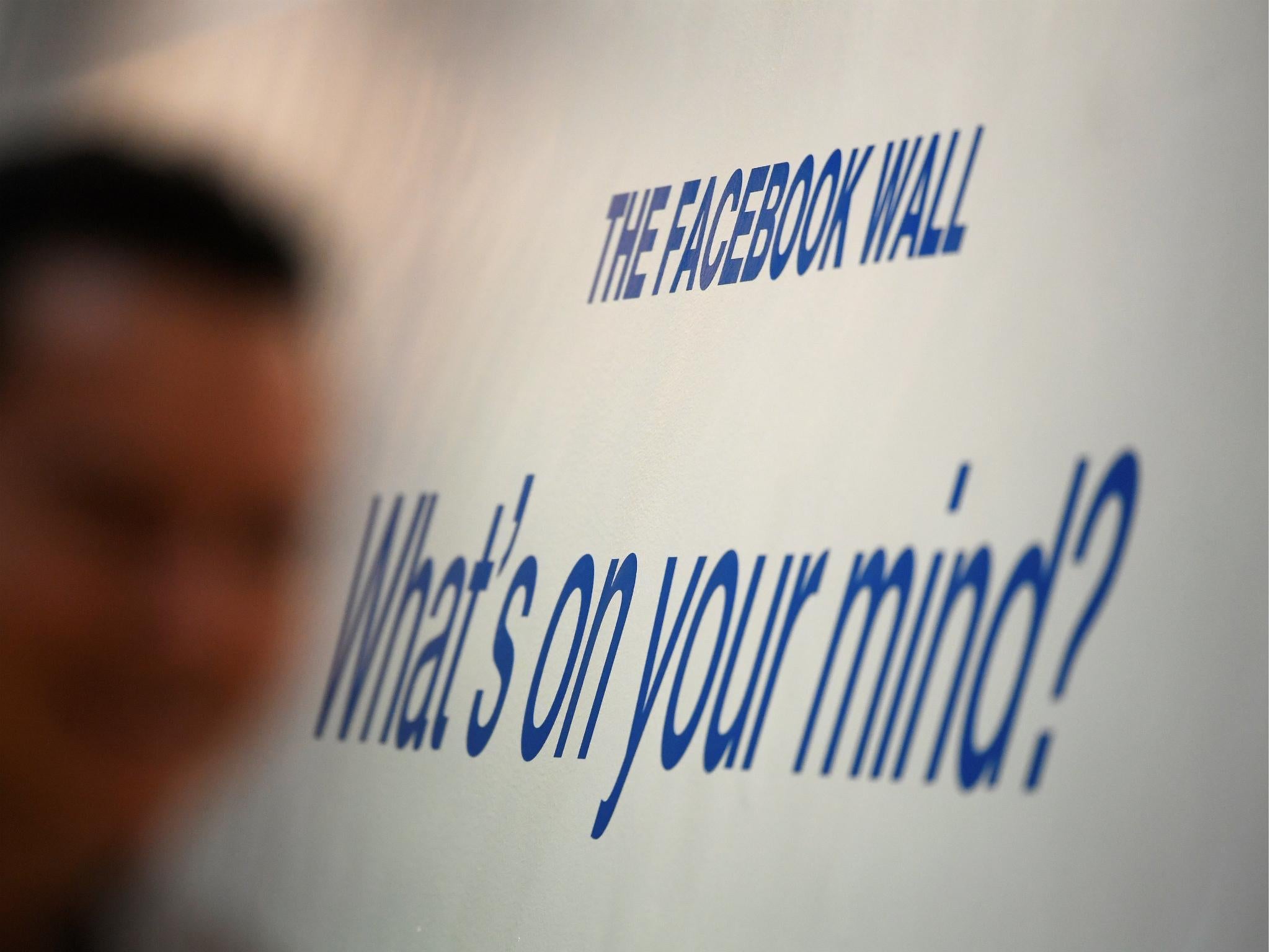 A man walks past a slogan at Facebook's headquarters in London, Britain, December 4, 2017