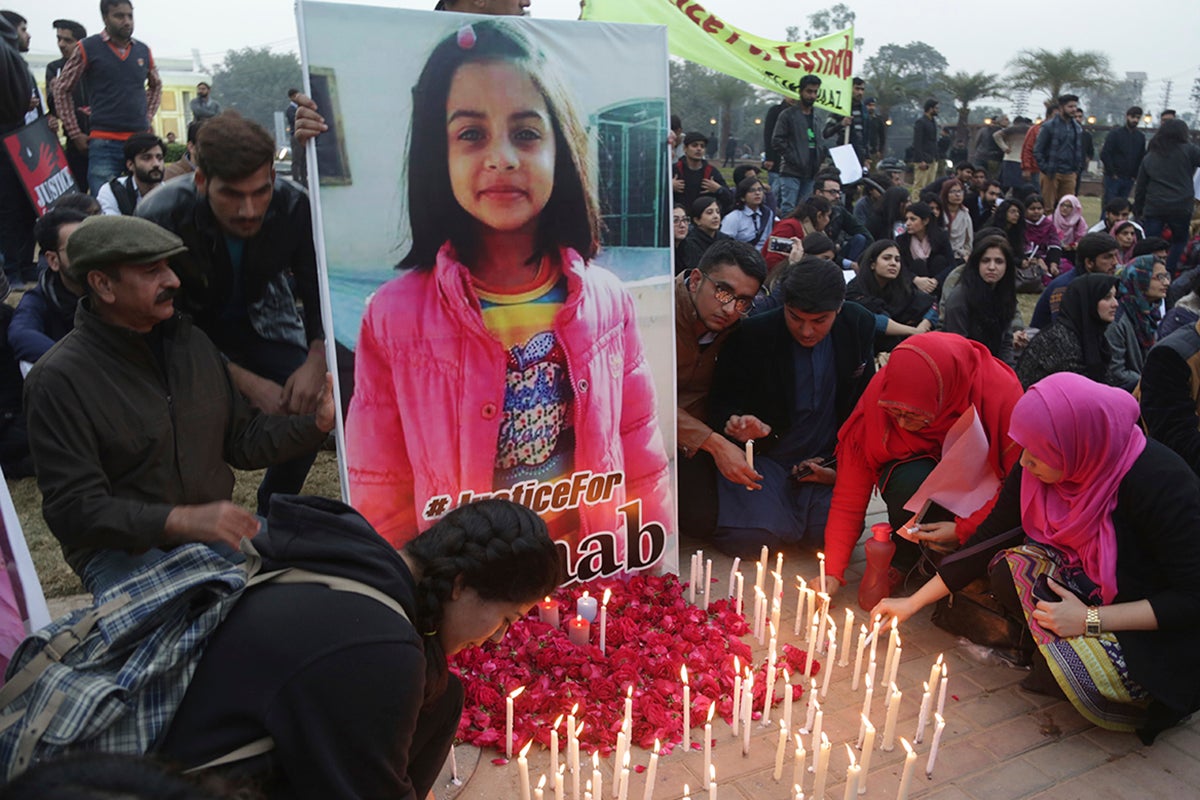 Pakistani students light candles during a protest rally to condemn the rape and killing of Zainab