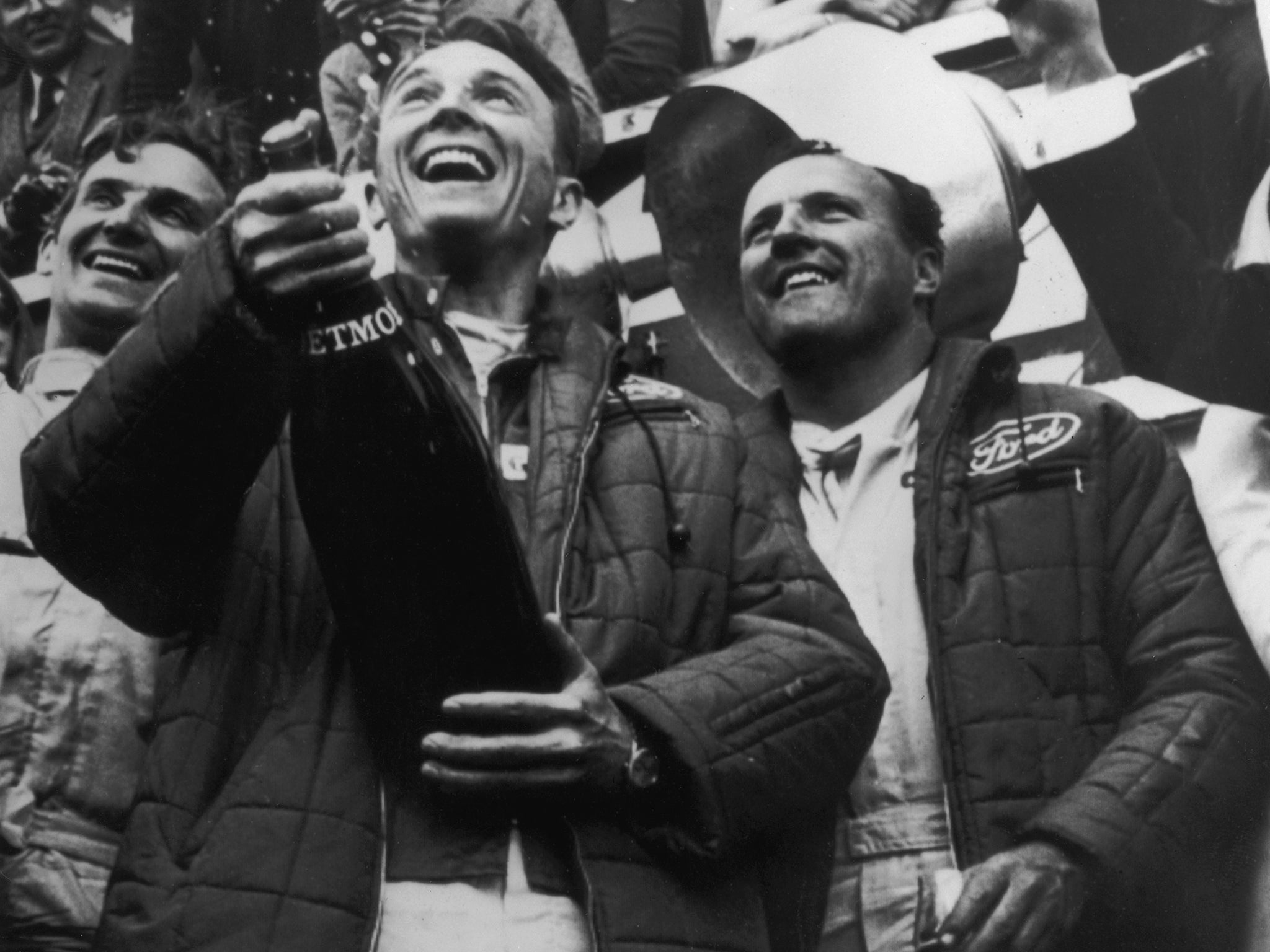 Gurney sprays champagne on the podium alongside AJ Foyt after winning the Le Mans 24 Hours