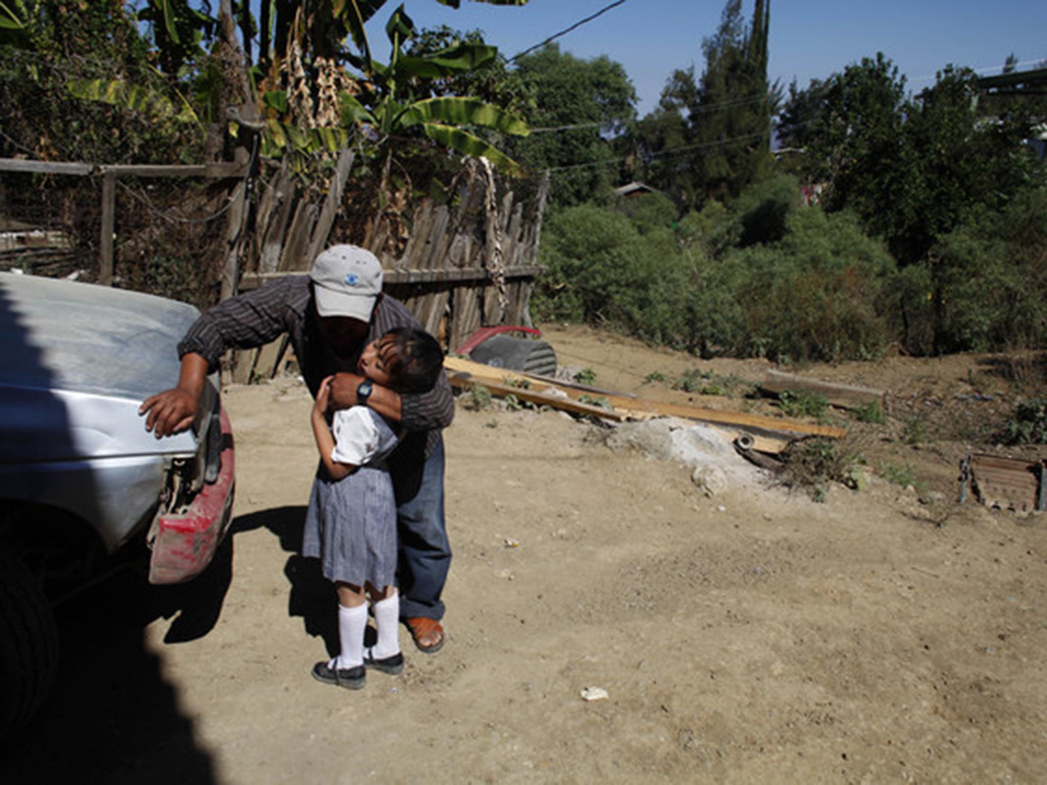 A farmer embraces his daughter in a community in the Sierra Madre del Sur mountains. Some growers are trying to give up poppy cultivation