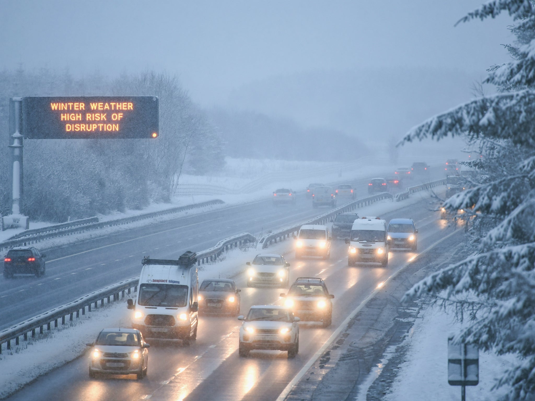 Motorists travel through heavy snow on the M8 in Scotland. Police Scotland urged drivers to only travel if necessary and to keep warm clothes and supplies in vehicles in case of emergency