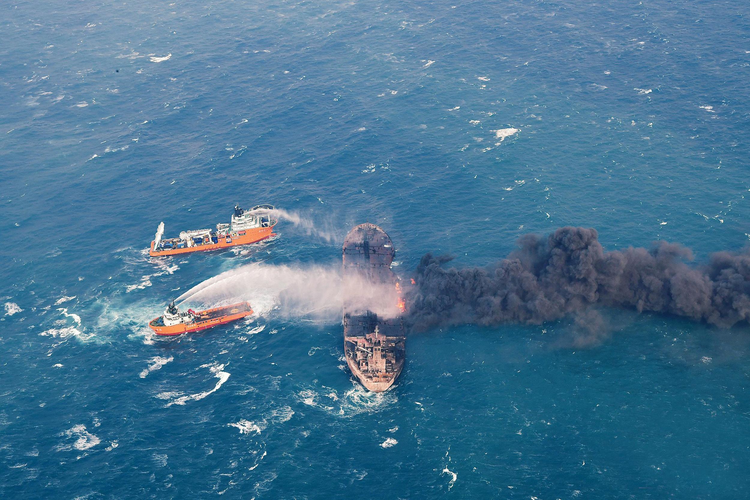 Firefighting boats work to put out a blaze on the oil tanker Sanchi