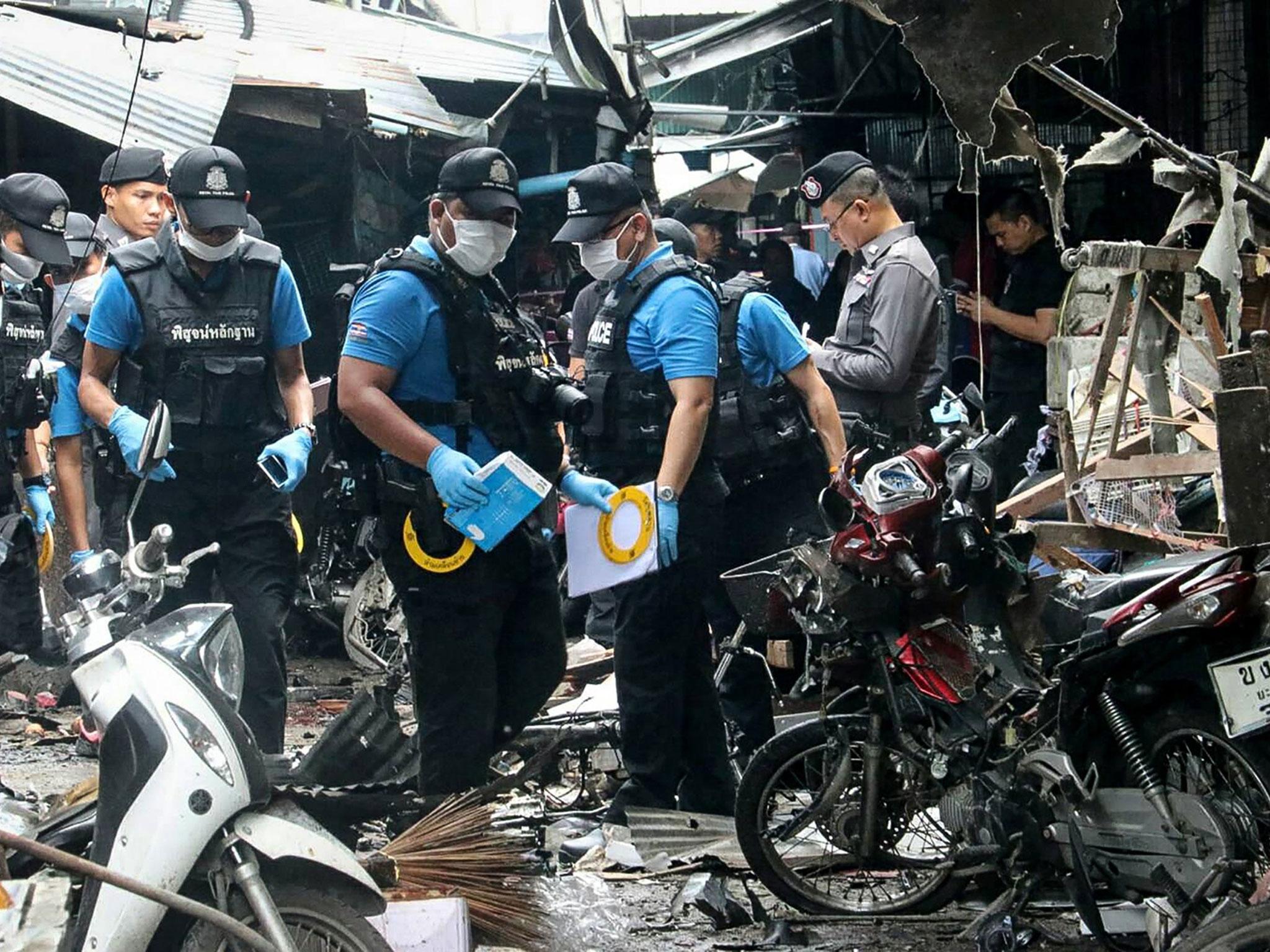 A Thai forensics unit scours the aftermath of a motorcycle bombing which killed three civilians and wounded others at a market in the restive southern Thai province of Yala