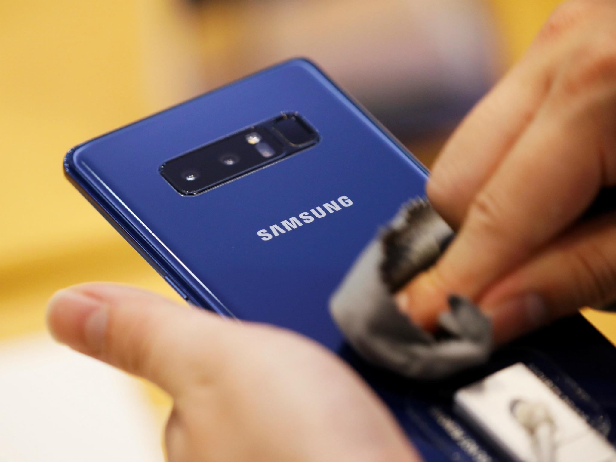 An employee wipes a Samsung Electronics Galaxy Note 8 at its office building in Seoul, South Korea, August 25, 2017