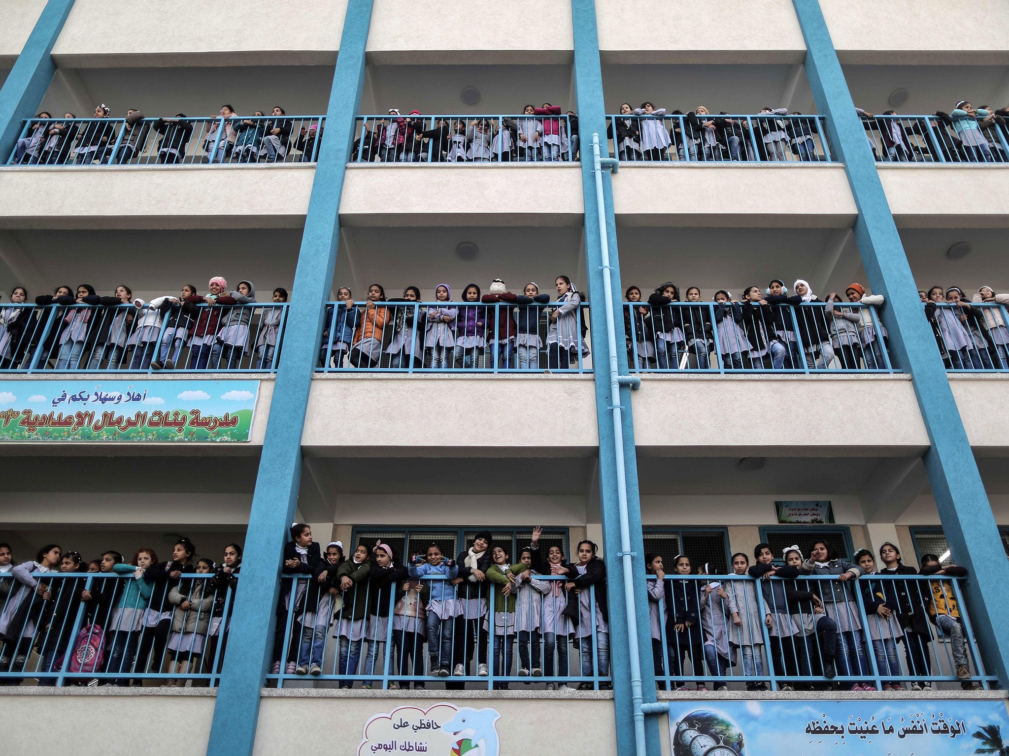 Palestinian schoolgirls pose for a group picture outside their classrooms at a school belonging to the United Nations Relief and Works Agency for Palestine Refugees (UNRWA) in Gaza City on 22 January 2018