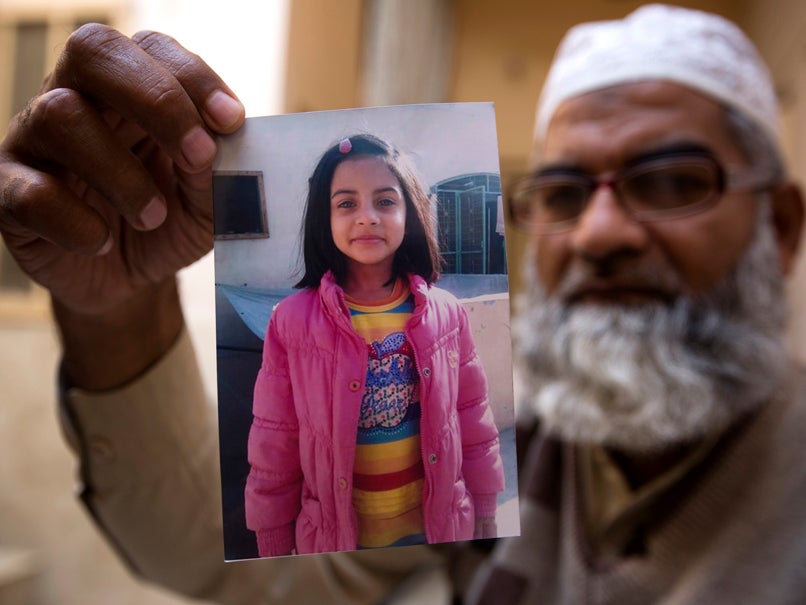 Zainab Ansari's father Mohammed Amin holds up a picture of his daughter