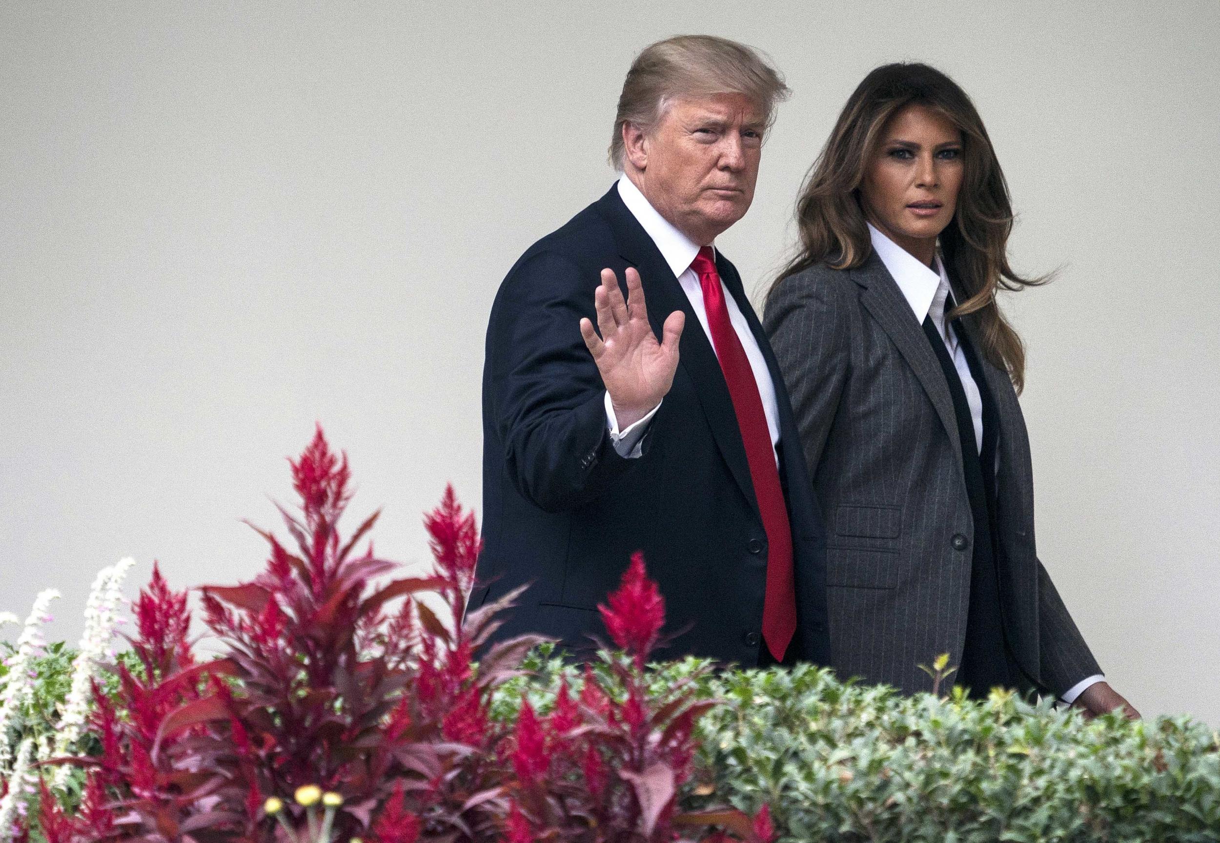 President Donald Trump walks with first lady Melania Trump at the White House in October