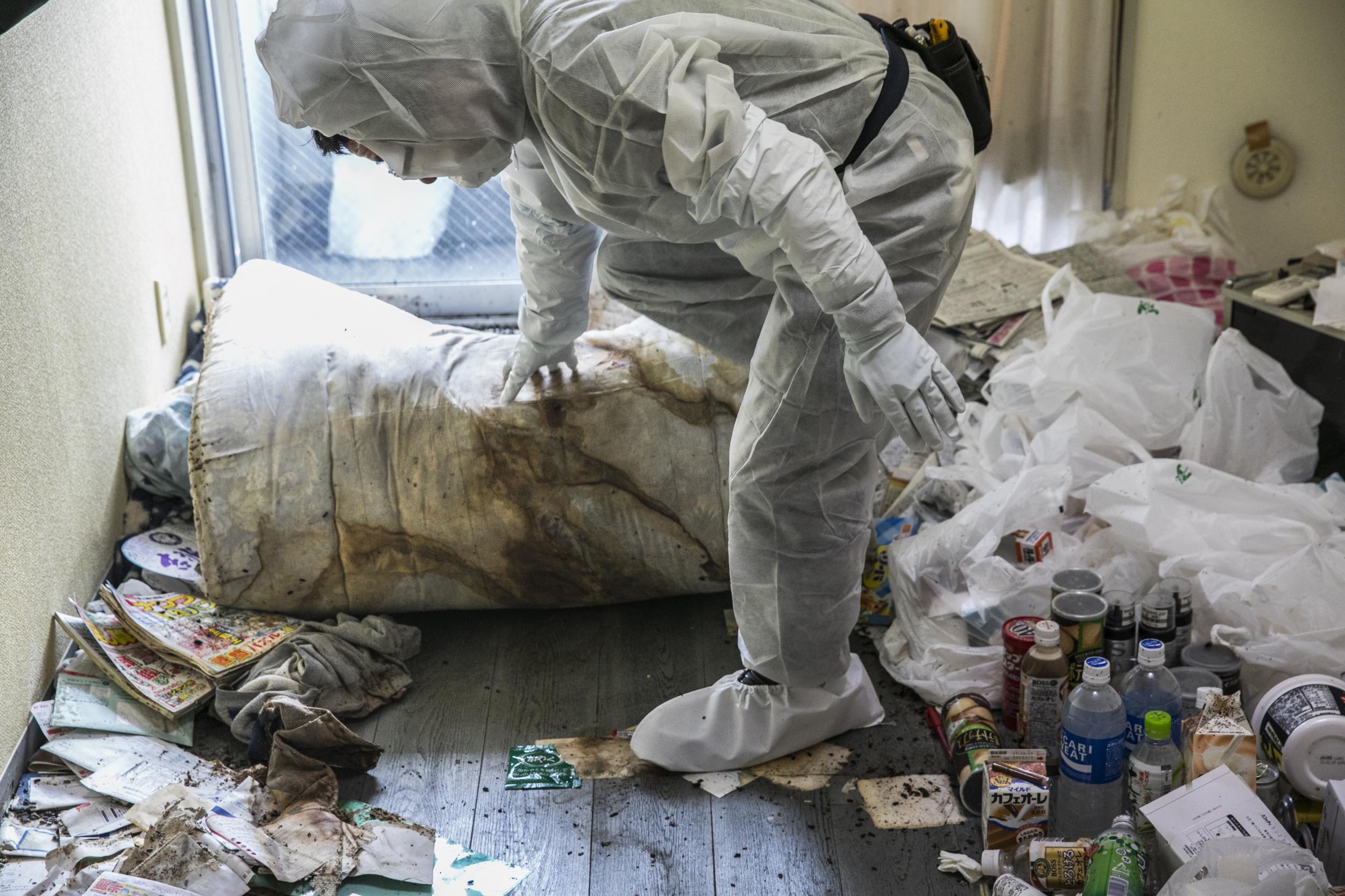 Fujita lifts the futon where Hiroaki’s body was found (Shiho Fukada/Washington Post)