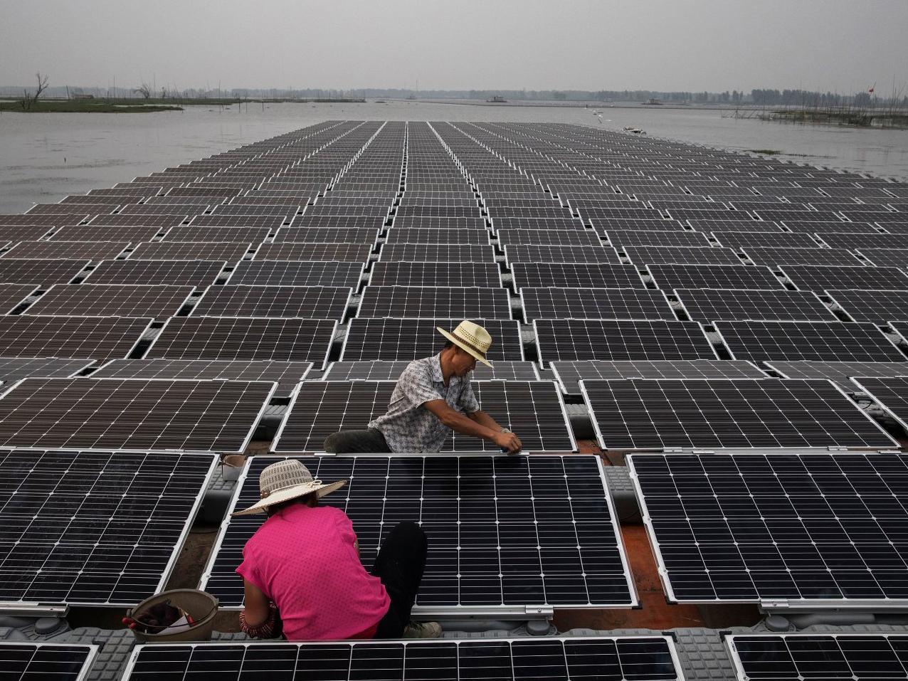 Workers prepare panels on the Chinese solar farm