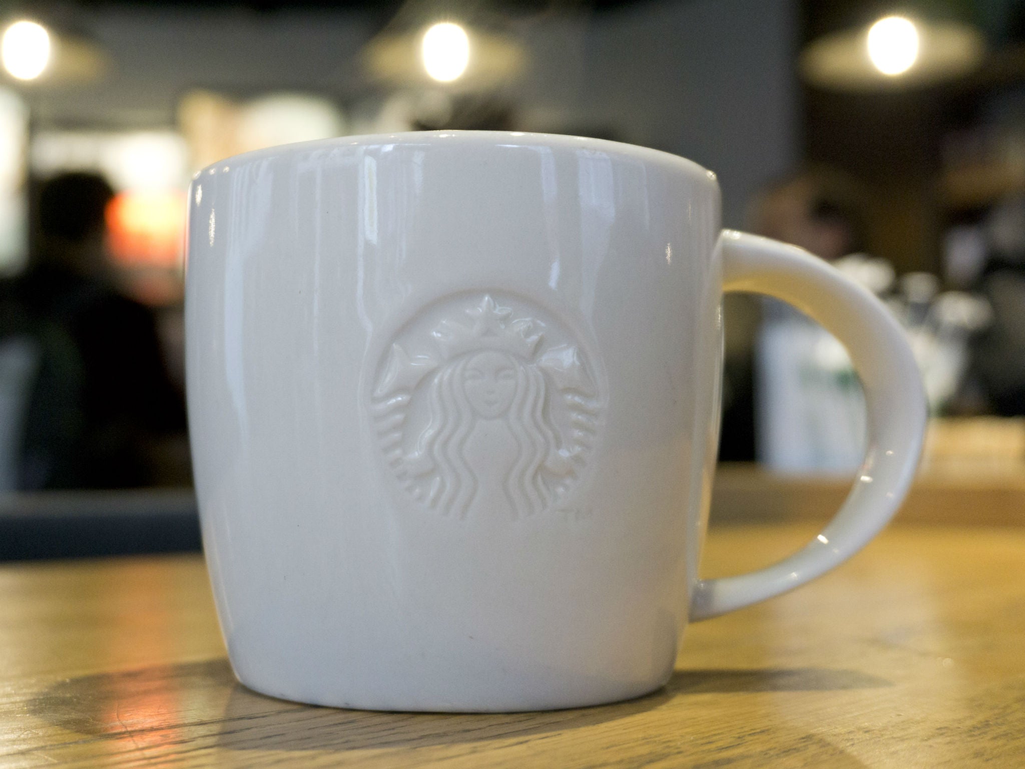 A mug of coffee is pictured above a Starbucks coffee shop