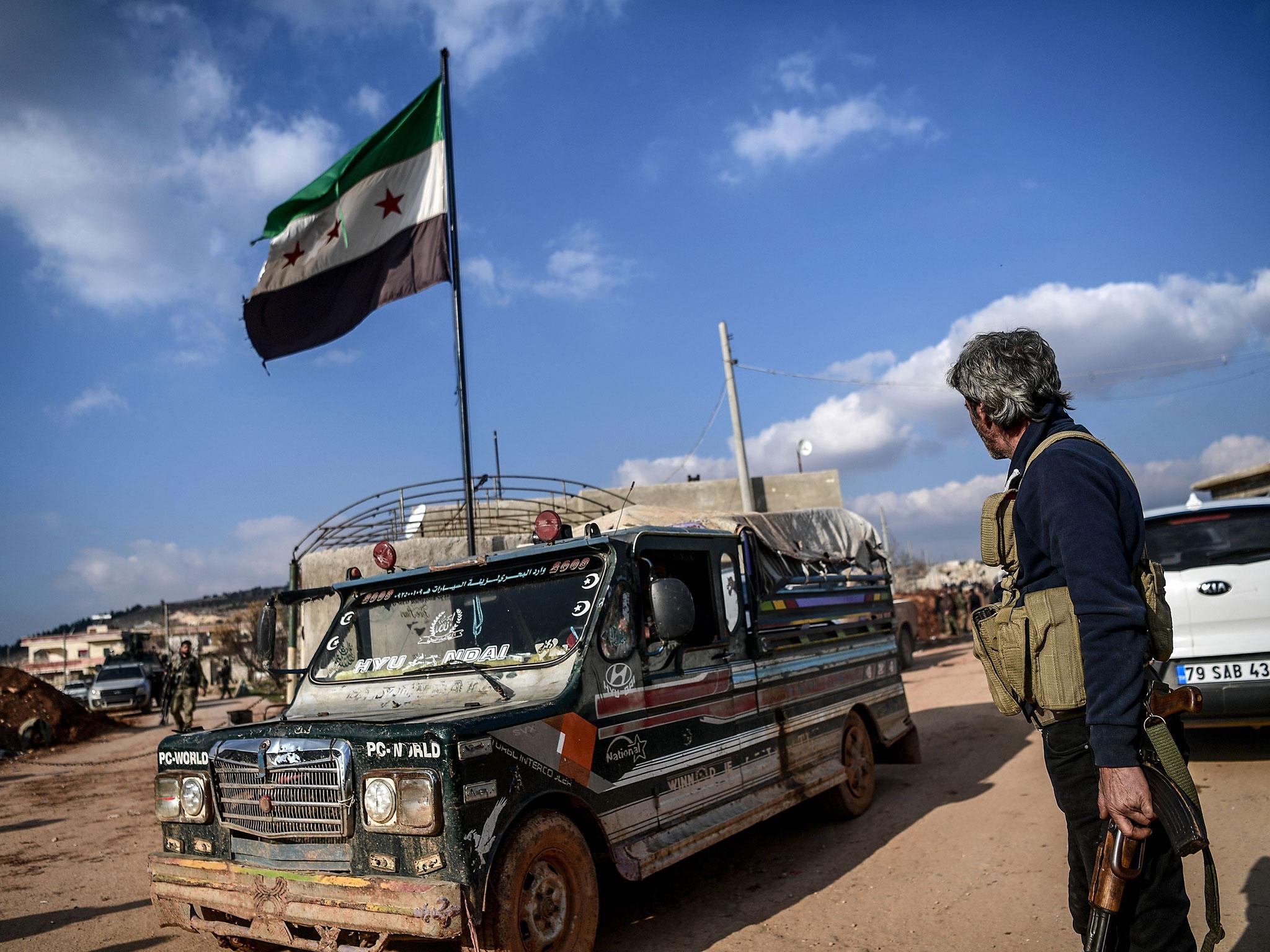 A Turkish-backed Syrian rebel fighter stands guard at a checkpoint in the Syrian town of Azaz on a road leading to Afrin