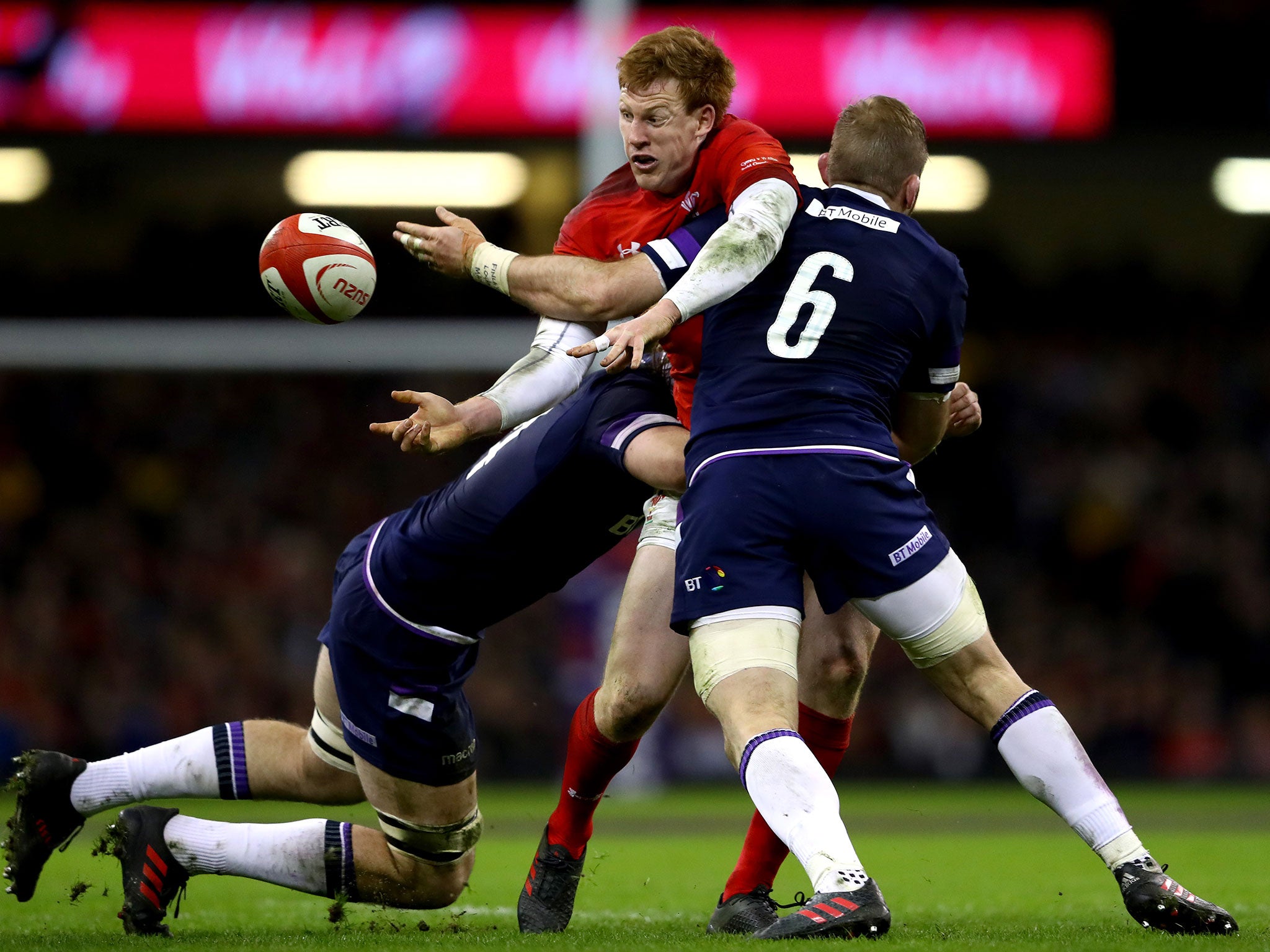 Rhys Patchell does his best to get a pass away under pressure from the Scottish defence