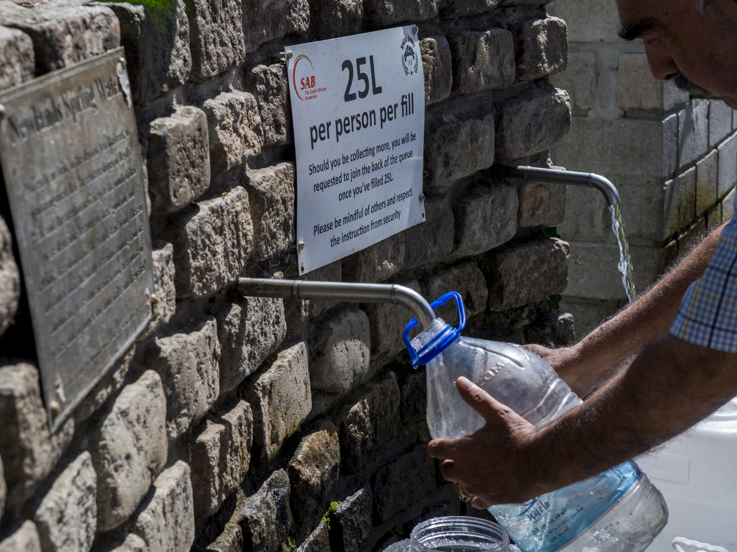 People are queuing to collect water from a natural spring outlet in the South African Breweries in Cape Town, while tourists are being asked to flush the toilet as little as possible