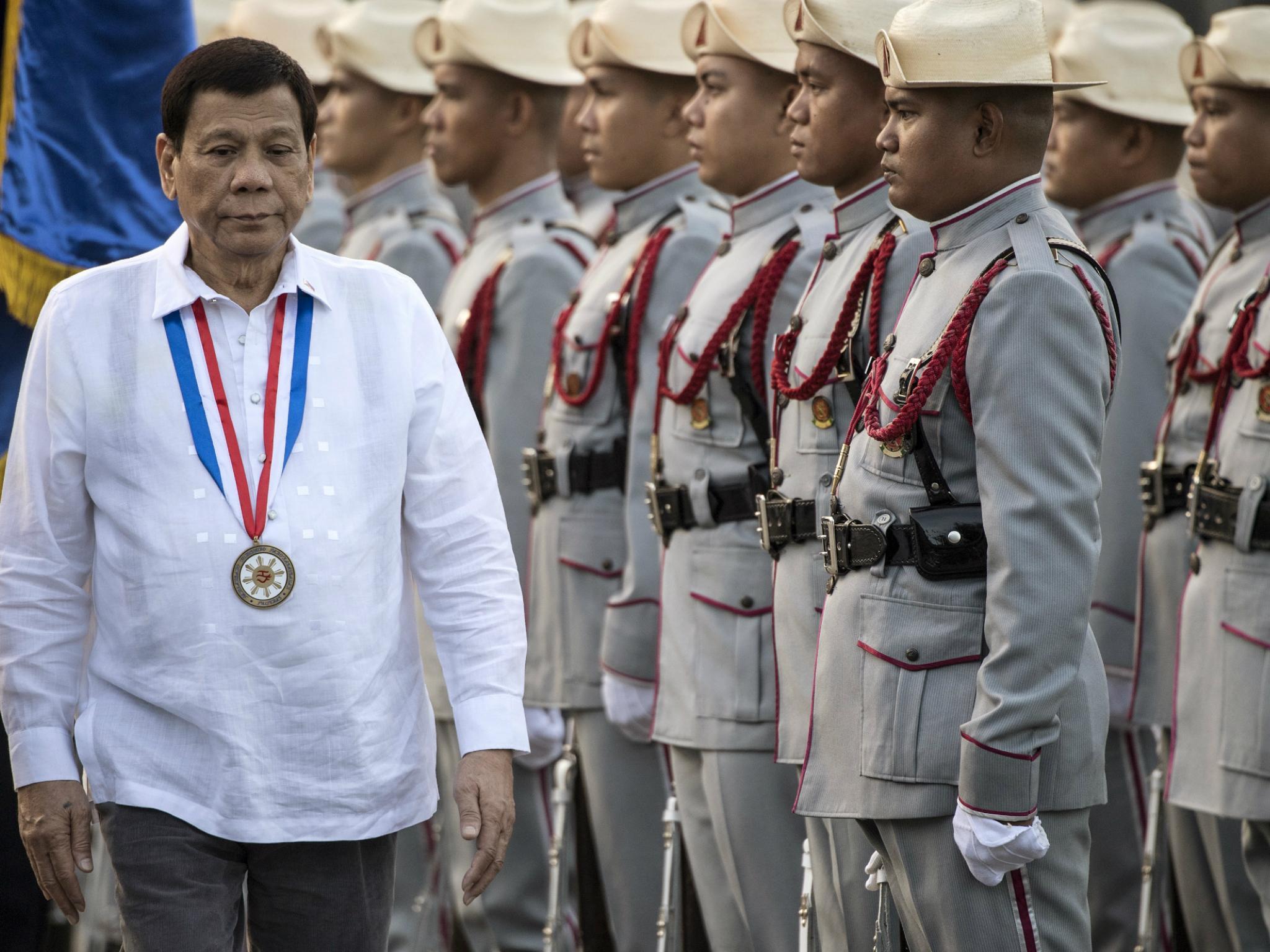 Philippines' President Rodrigo Duterte inspects the honour guards in Manila on 30 December 2017.