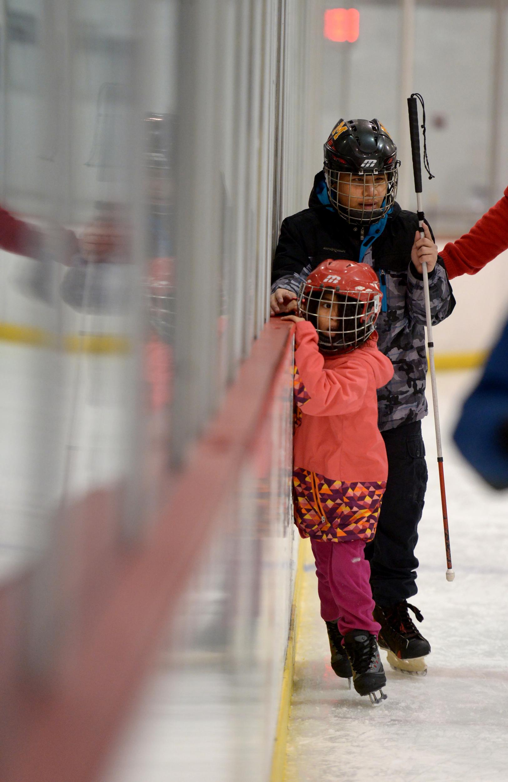 Anderson Ayala, 15, who is visually impaired and Leslie Saenz, 5, who is sighted, try ice skating for the first time