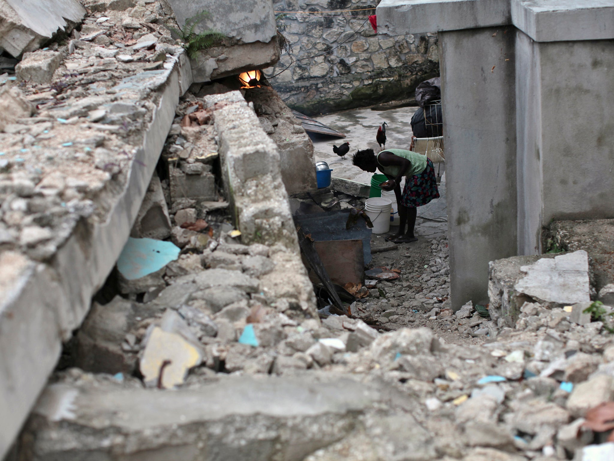 A Haitian woman surrounded by debris of a house destroyed by the January 2010