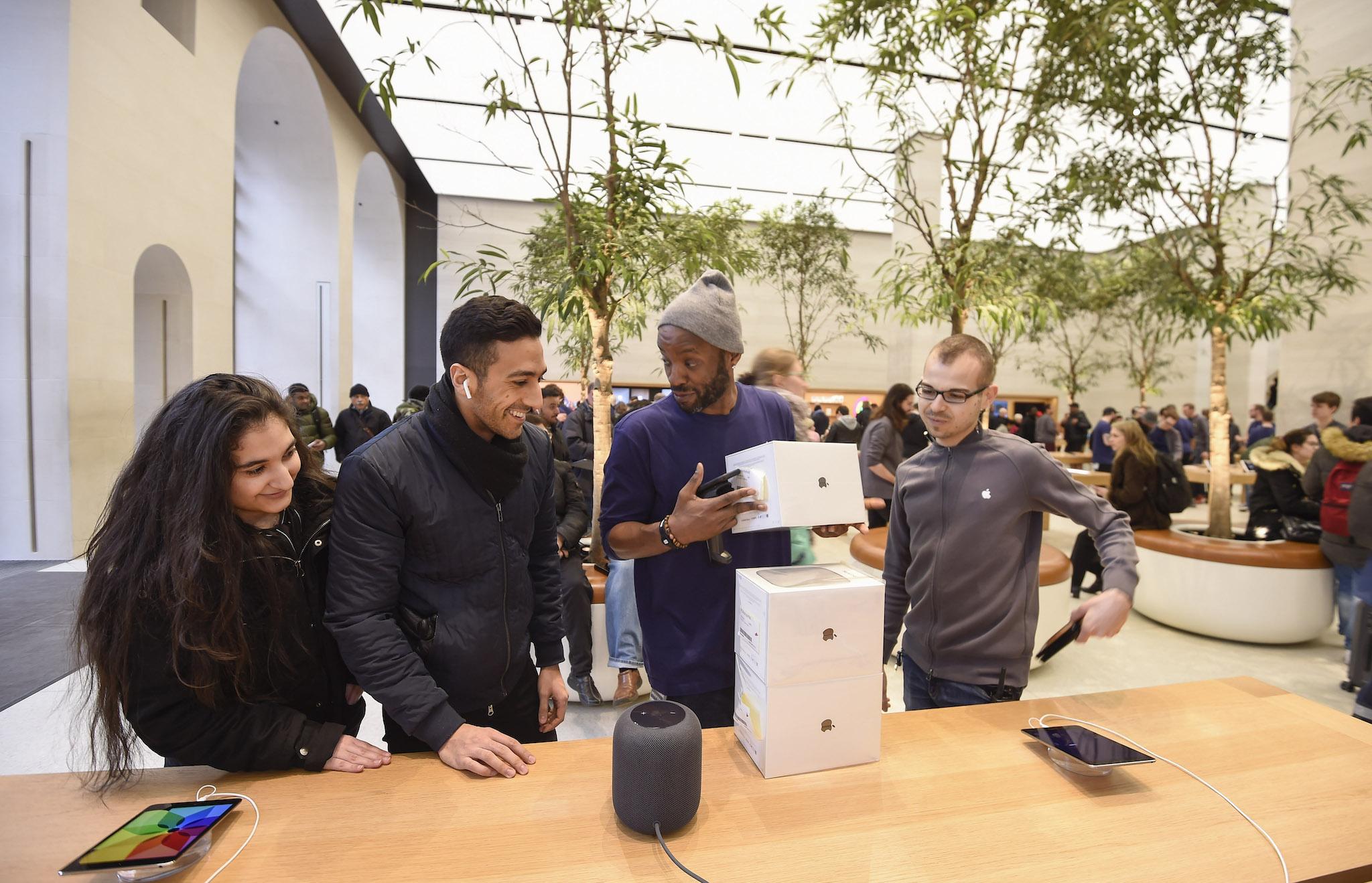 Customers look at The Apple HomePod, which is now available in stores in the US, UK and Australia, at Apple Store on Regent Street