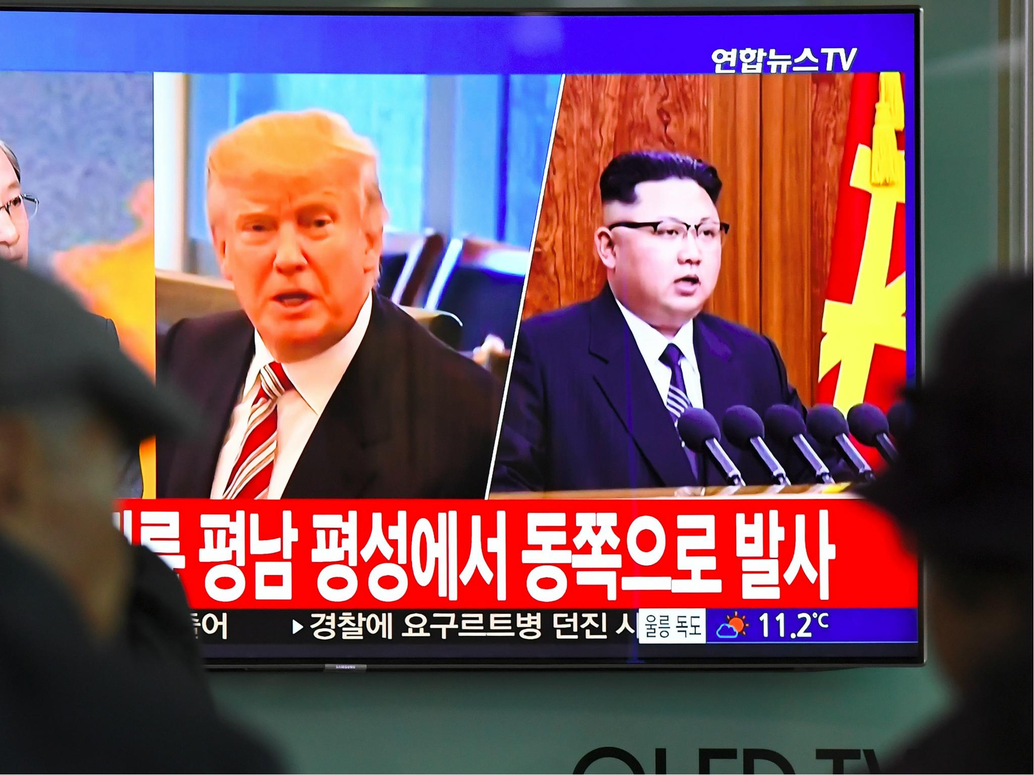 People watch a television news screen showing pictures of US President Donald Trump and North Korean leader Kim Jong-Un at a railway station in Seoul, South Korea.