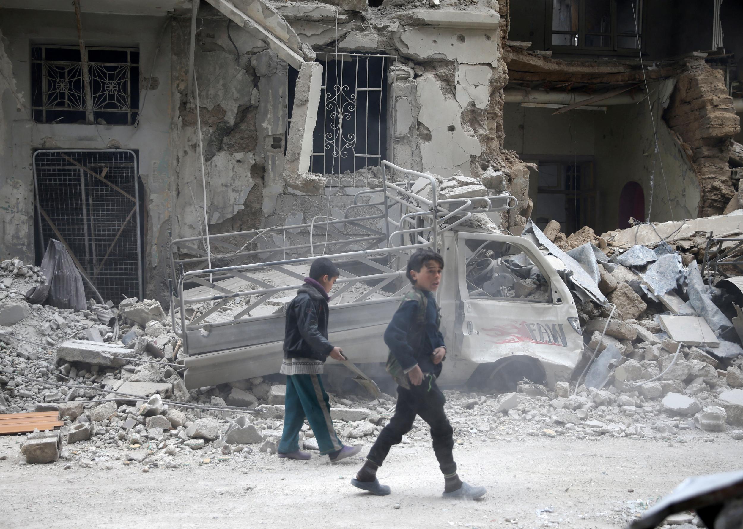 Children inspect damage on a street in the besieged town of Douma, Eastern Ghouta