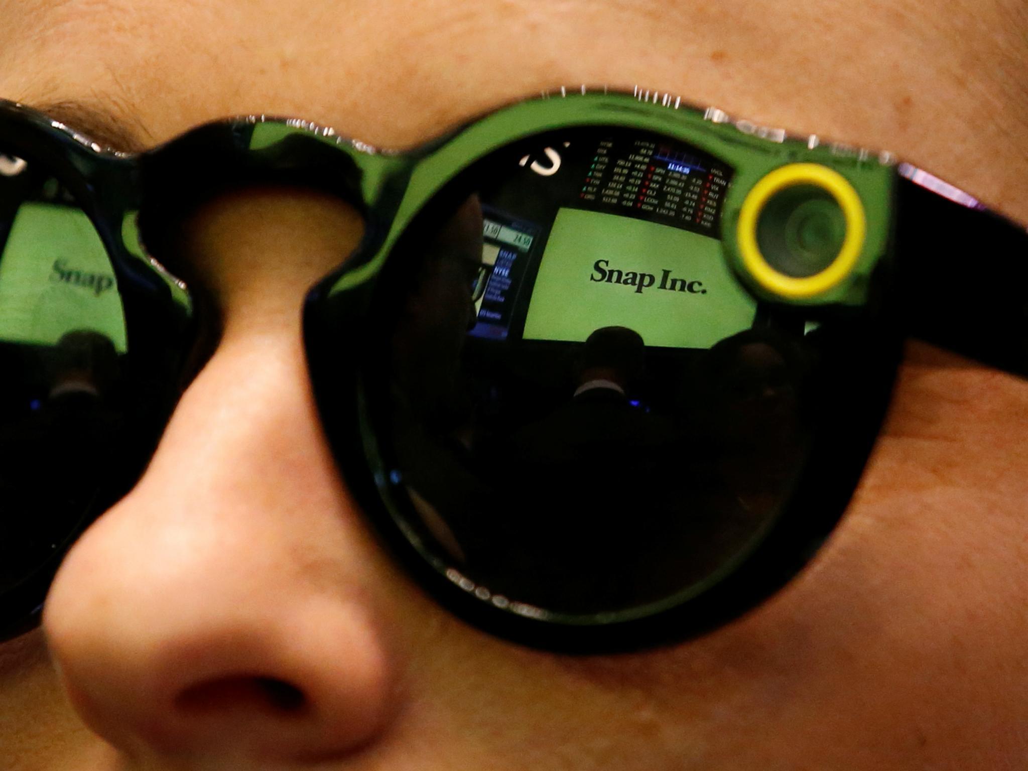 A woman wears Snapchat Spectacles on the floor of the New York Stock Exchange (NYSE) while waiting for Snap Inc. to list their IPO in New York, U.S., March 2, 2017