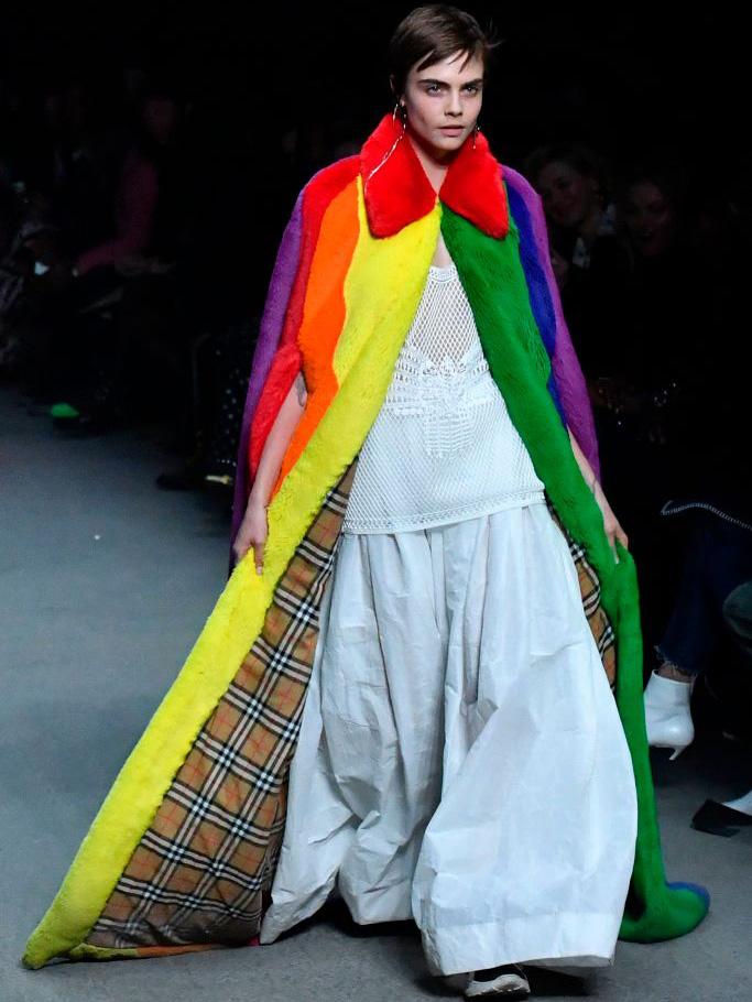 Cara Delevingne wears a floor-sweeping, check-lined cape in multicoloured stripes at Burberry’s show (AFP/Getty)