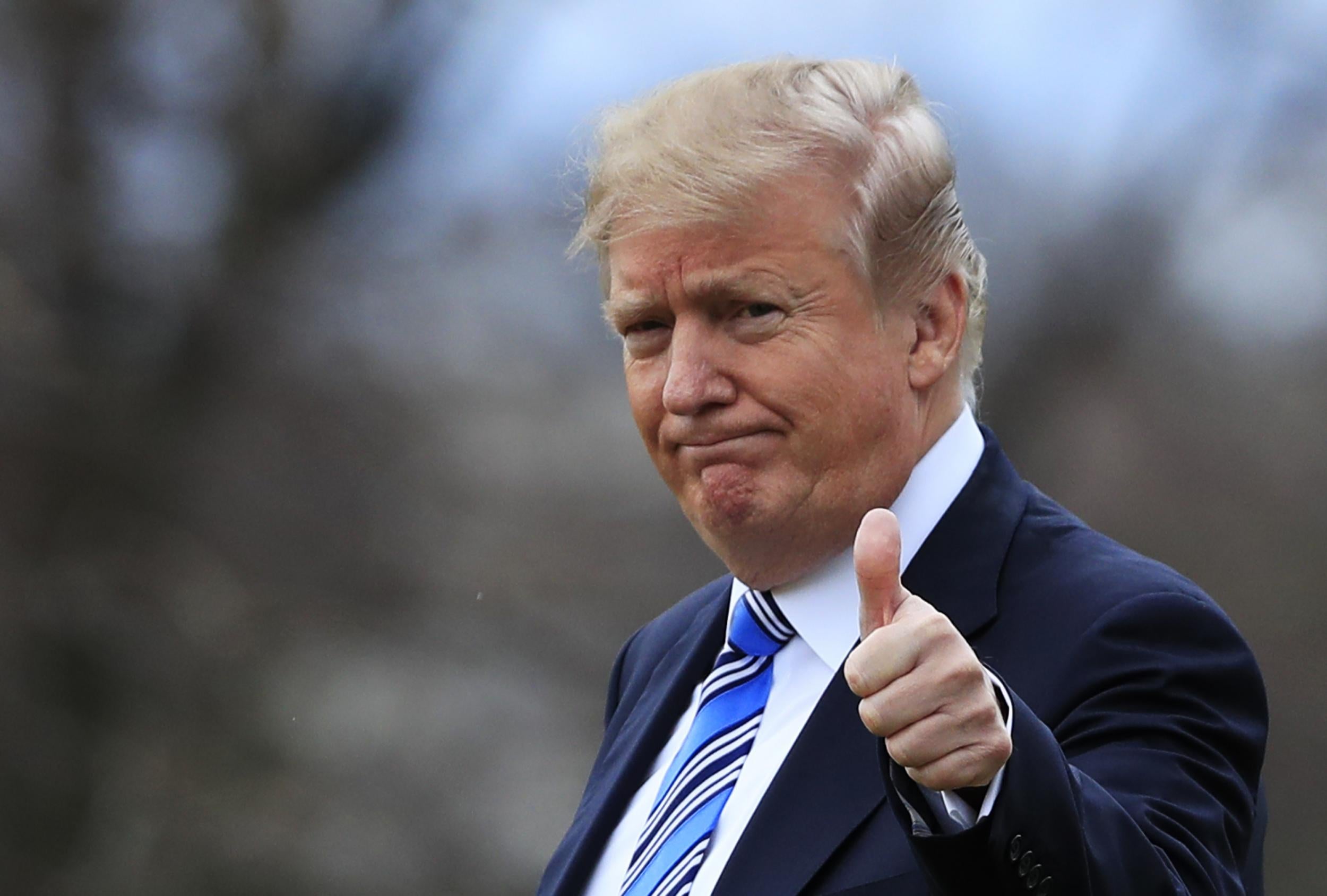 Donald Trump gestures to the media as he leaves the White House