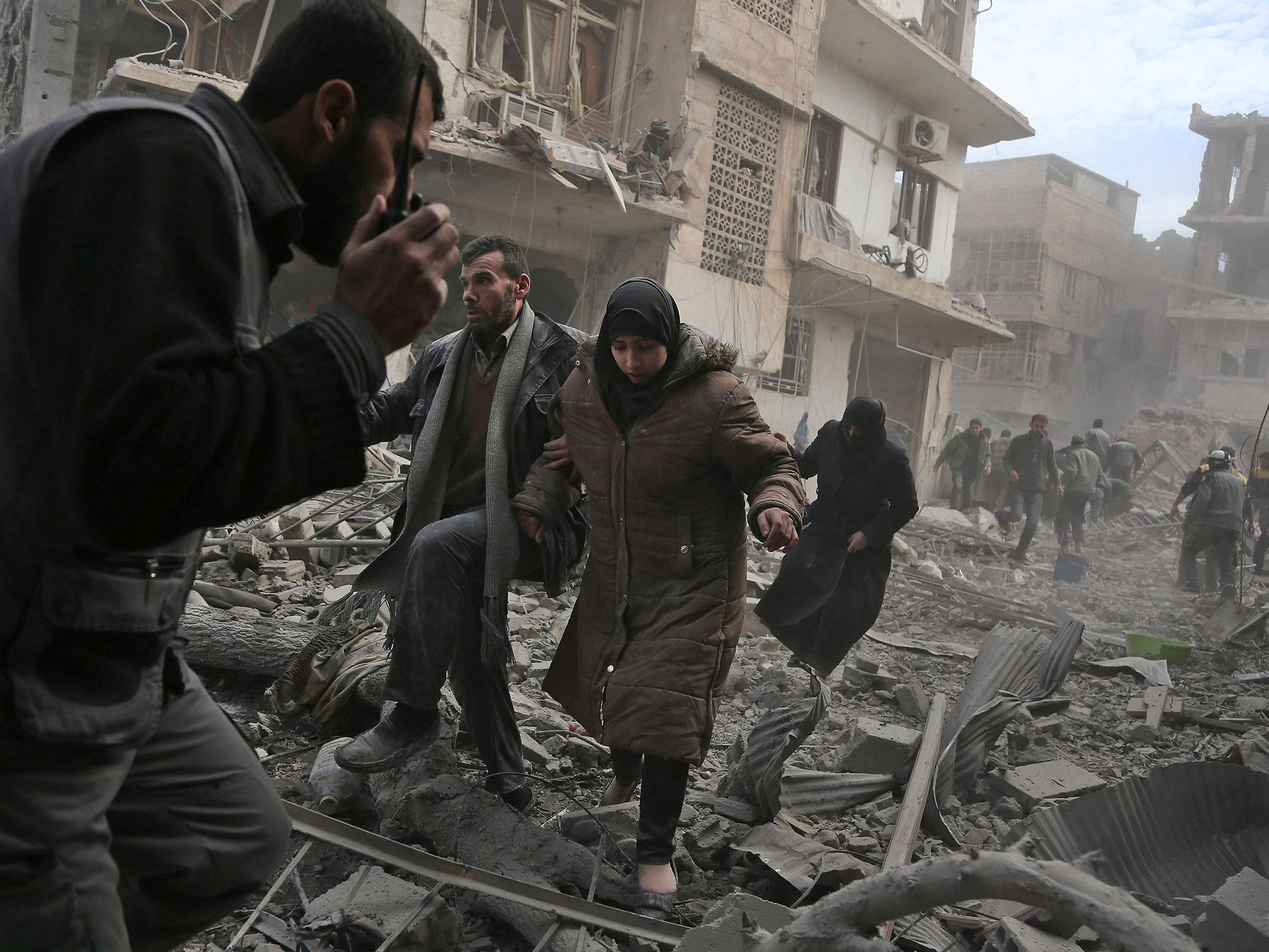 Civilians flee from an area hit by a reported regime air strike in Eastern Ghouta