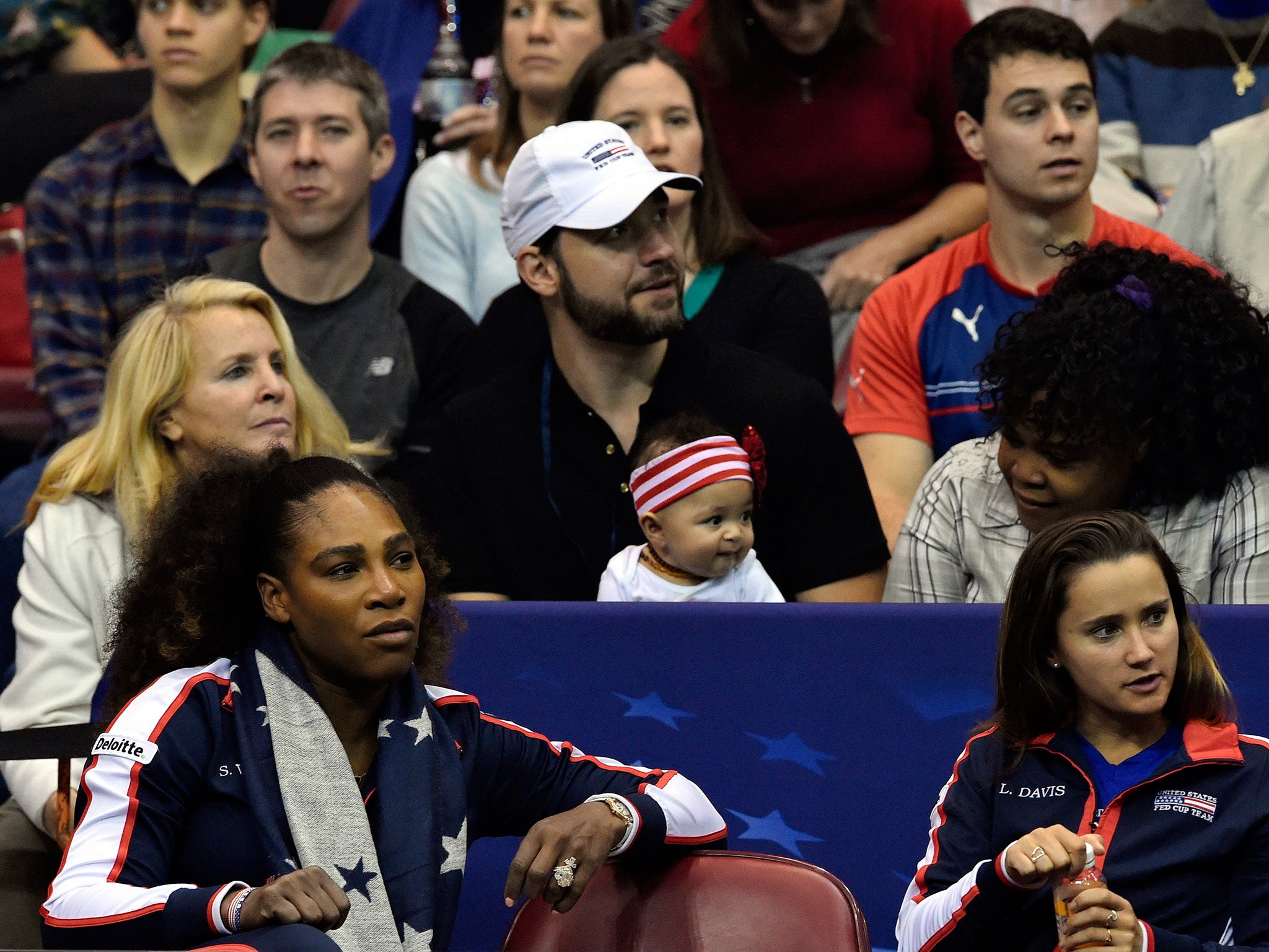 Williams sitting in front of her husband Alexis Ohanian and their daughter Olympia