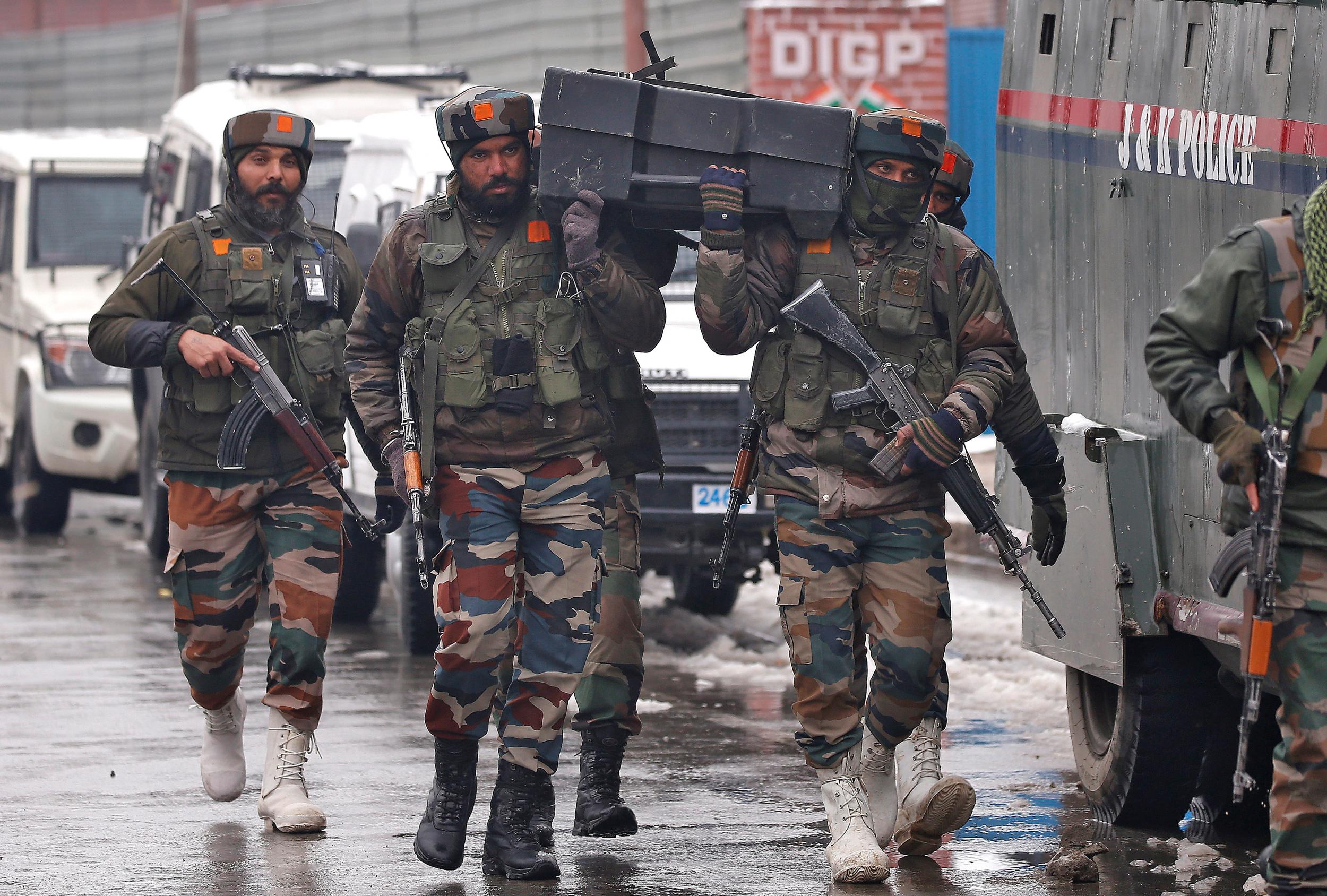 Indian soldiers carry a box containing bulletproof shields near the site of a battle with suspected militants in Srinagar earlier this month