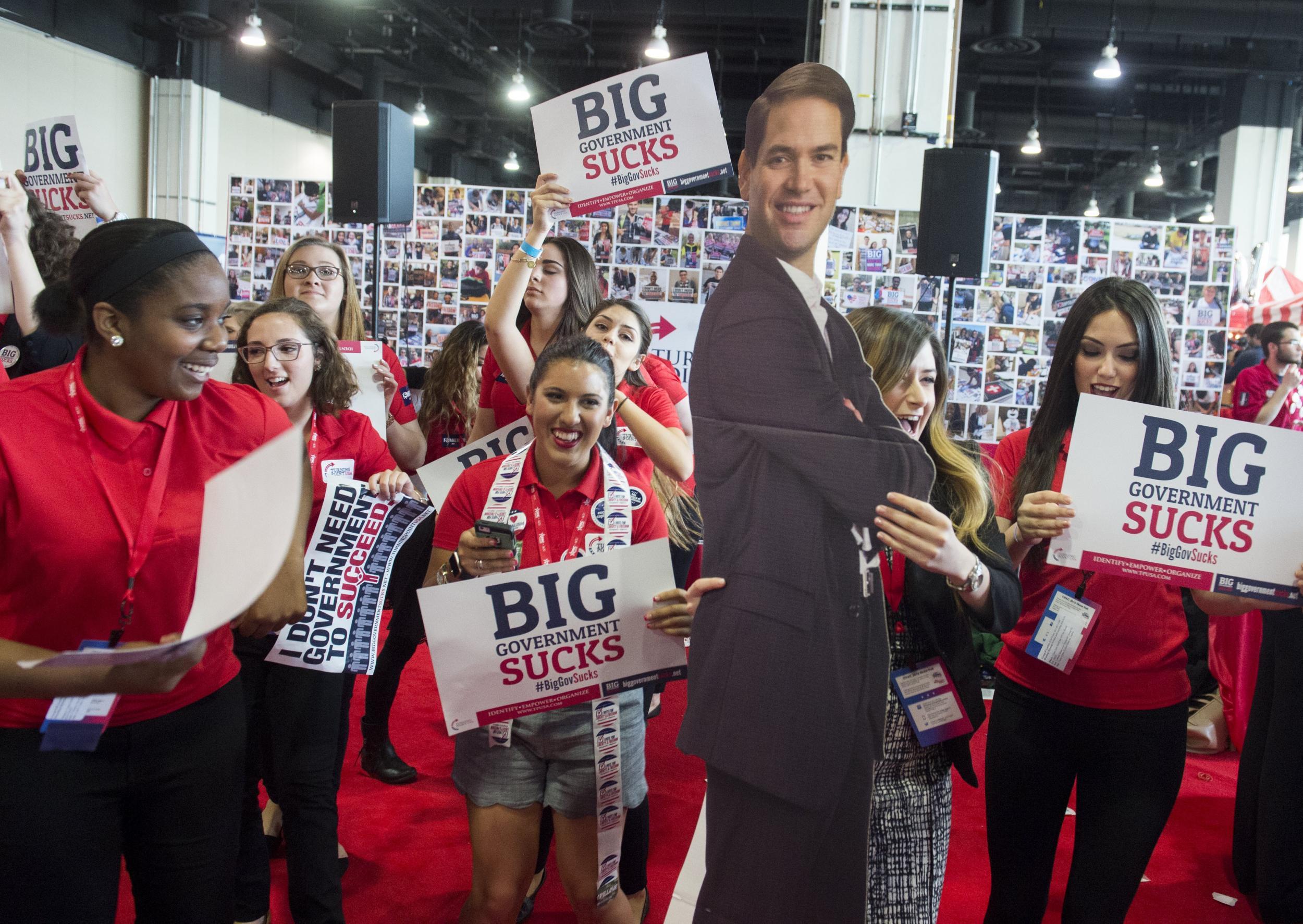 Turning Point USA members dance with a cutout of US Republican Presidential hopeful Senator Marco Rubio of Florida during the annual Conservative Political Action Conference