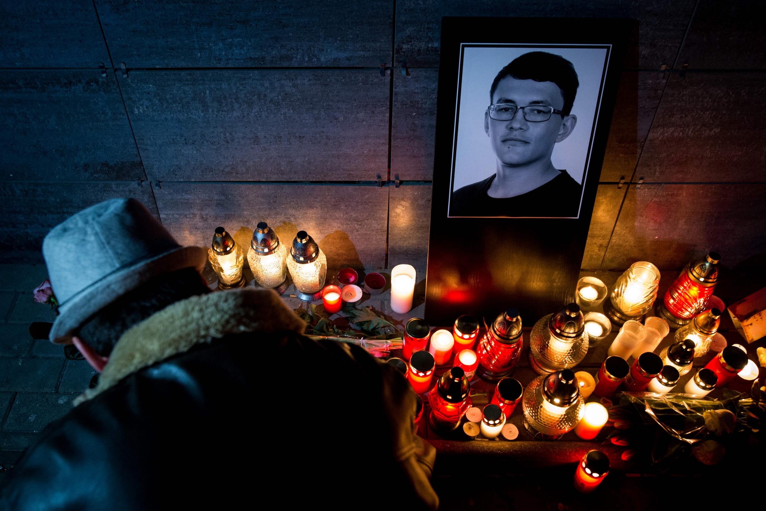 A man lights a candle in front of the Aktuality.sk newsroom, where Mr Kuciak worked (AFP/Getty)