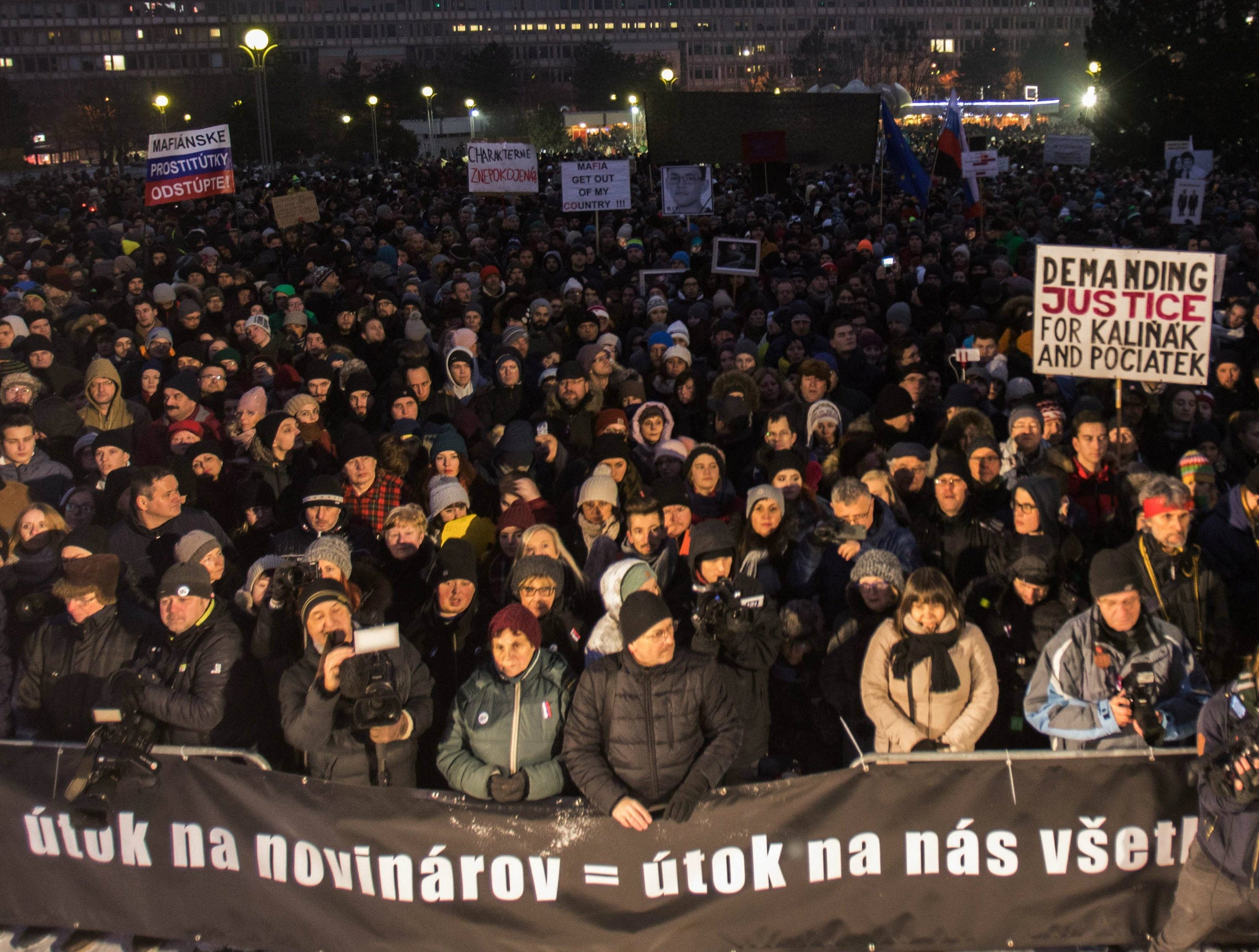 Protesters hold a banner saying an attack on journalism is an attack on everyone