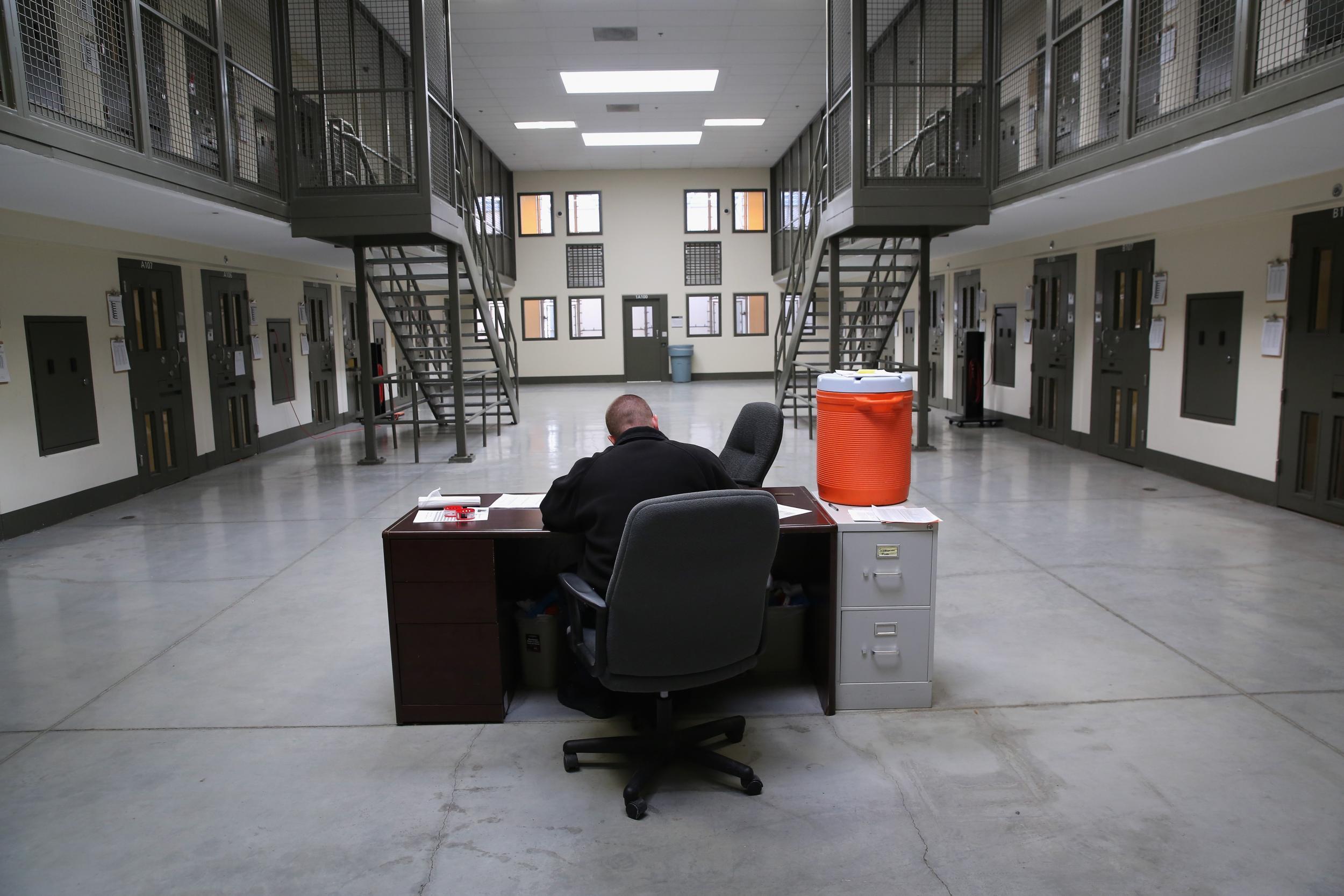 A guard sits in the ‘segregation block’ at a US immigrant detention facility (Getty)