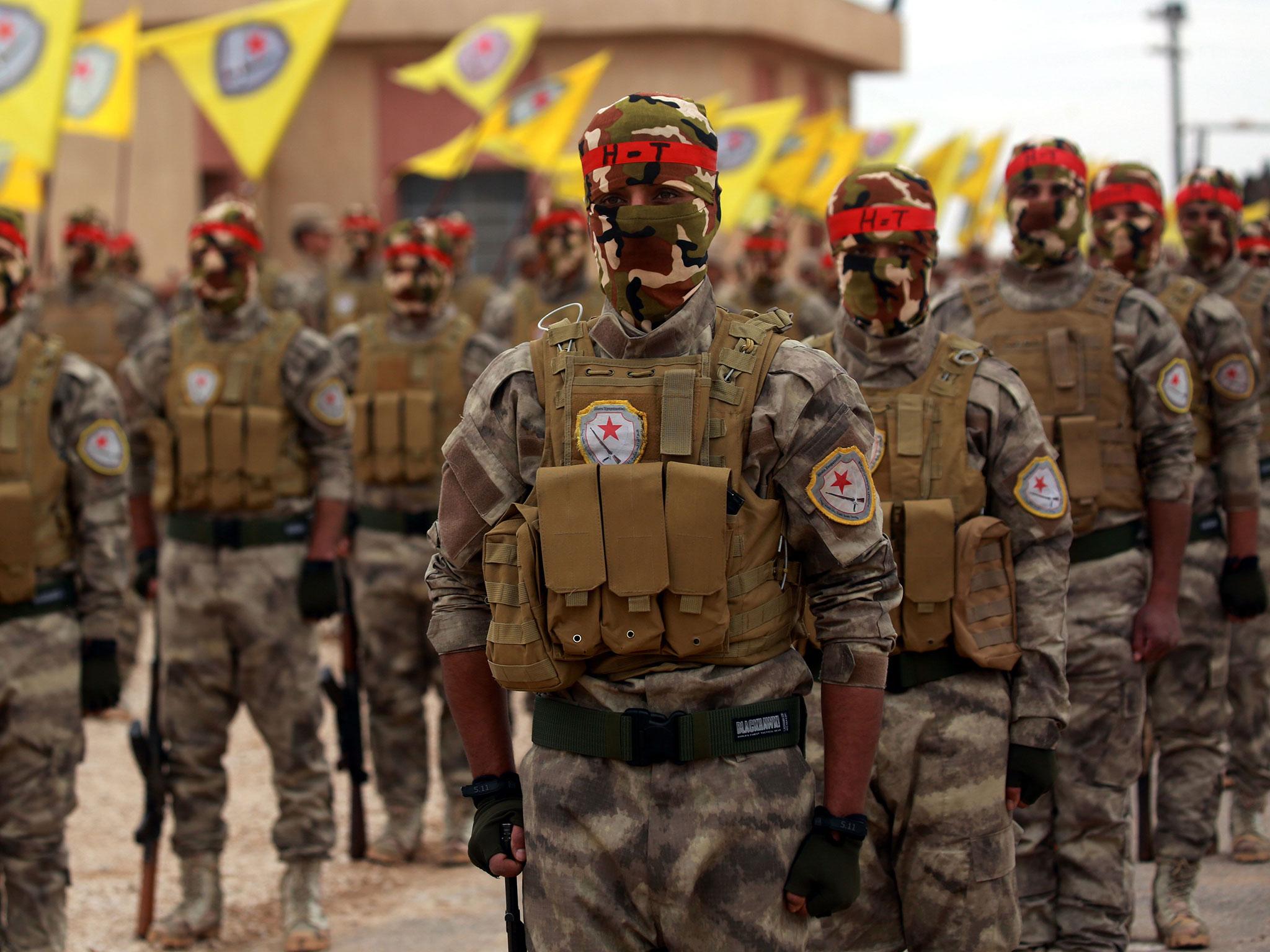 Arab and Kurdish fighters from the Self-Defence Forces (SDF) take part in a graduation ceremony in Qamishli on 1 March. They are witnessing the Isis comeback on the front line