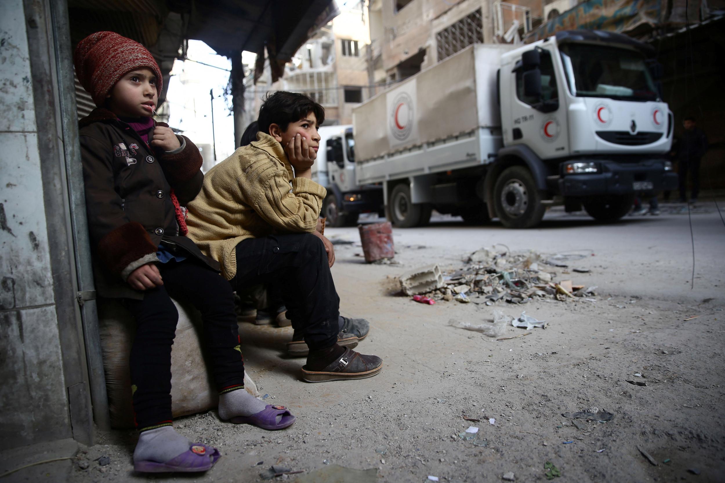 A relief convoy from the Syrian Arab Red Crescent rolls into the besieged town of Douma on Monday