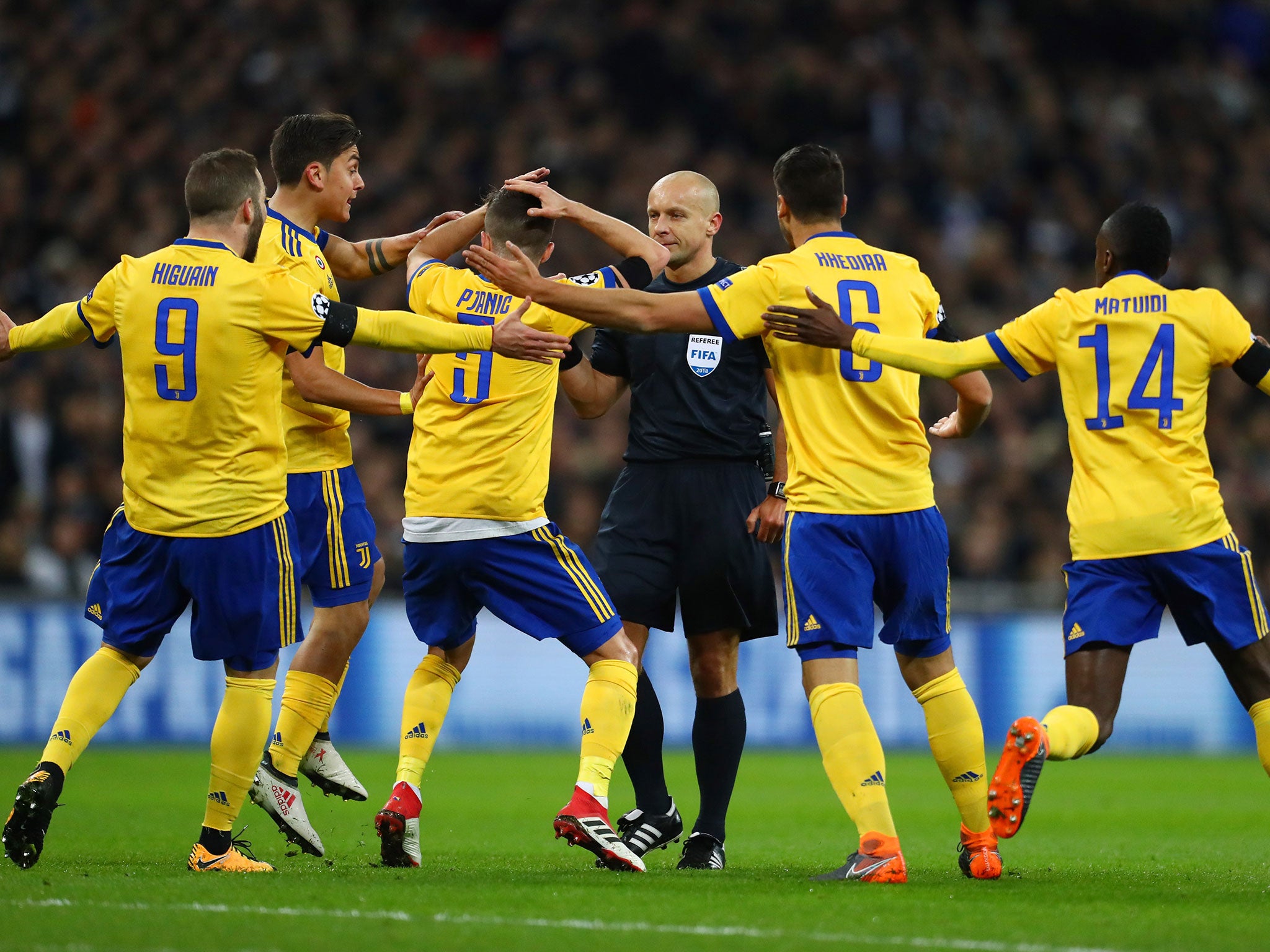 Juventus‘ players swarm the referee during Wednesday’s Champions League clash