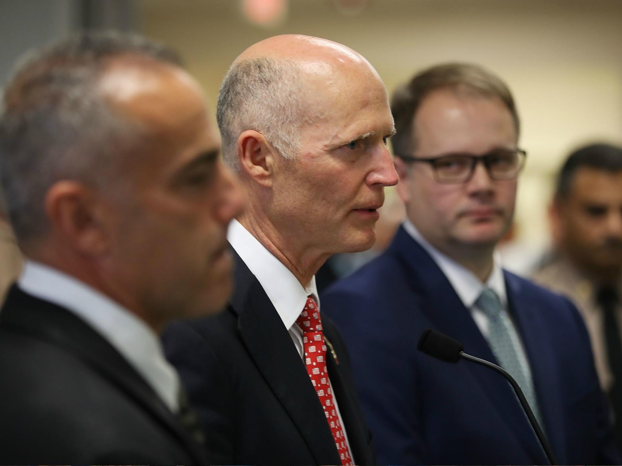 Florida Governor Rick Scott stands with Andy Pollack who lost his daugther Meadow Pollack, 18, and Ryan Petty who lost his daughter Alaina Petty,14, during the mass shooting at Marjory Stoneman Douglas High School on 27 February 2018.