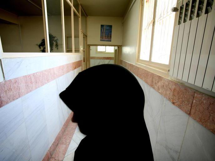 A female prison guard stands along a corridor in Tehran's Evin prison