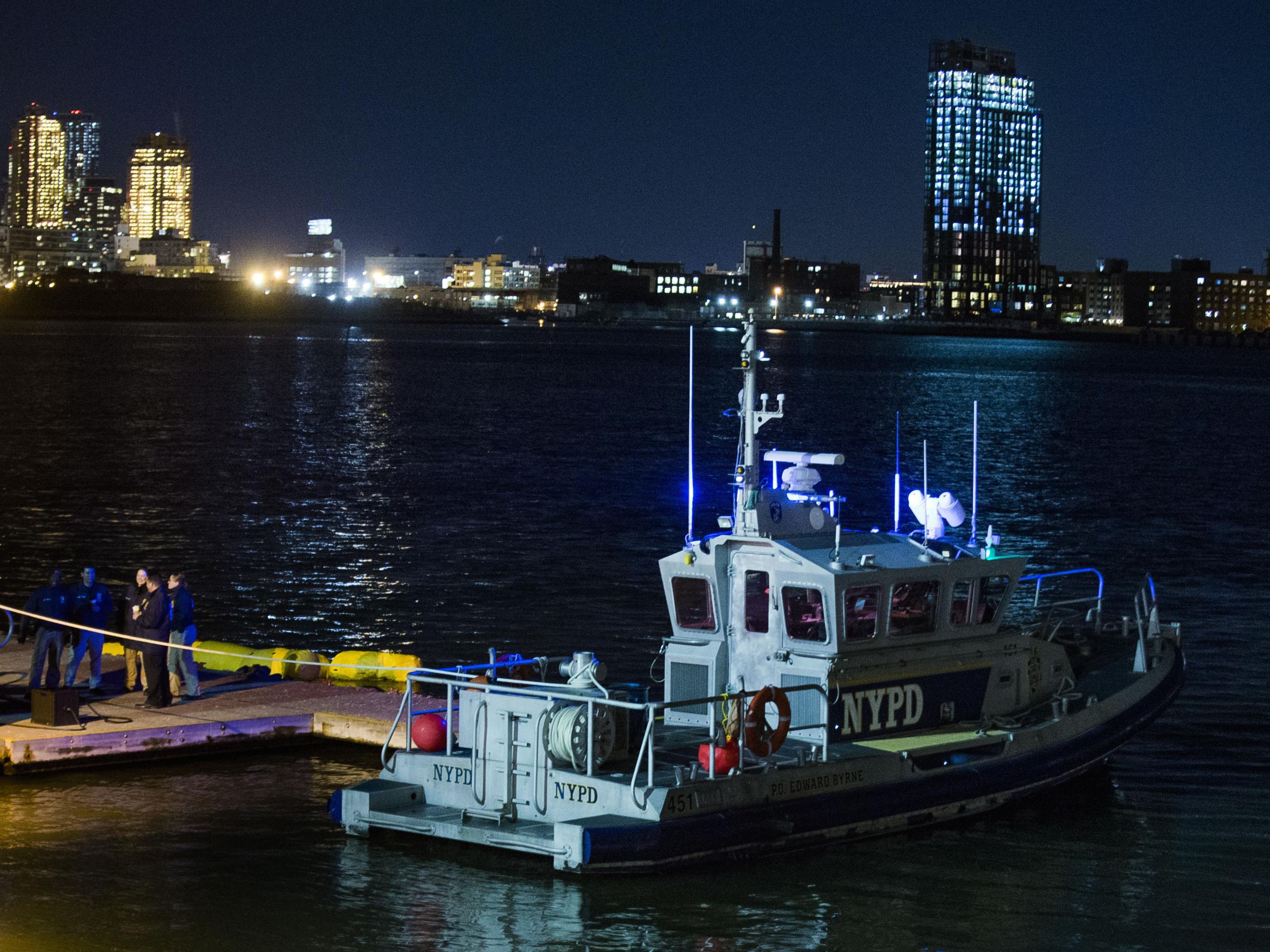 Yellow buoys that a New York police officer said are suspending the helicopter that crashed on the East River float next to a NYPD police boat.