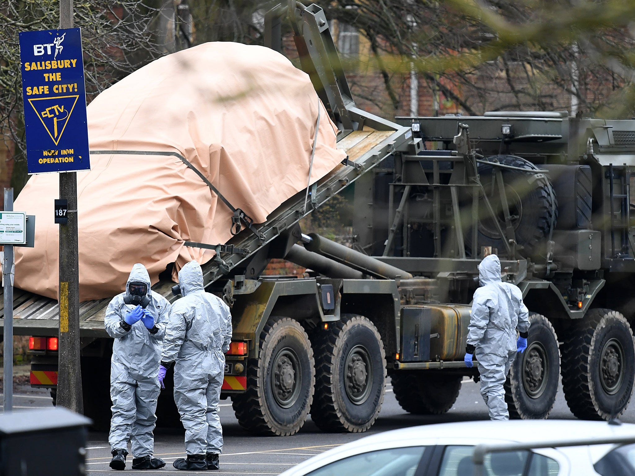 Military officials in protective clothing remove vehicles from a car park in Salisbury