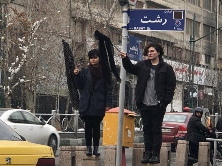 Women have been climbing on platforms to protest against compulsory hijab