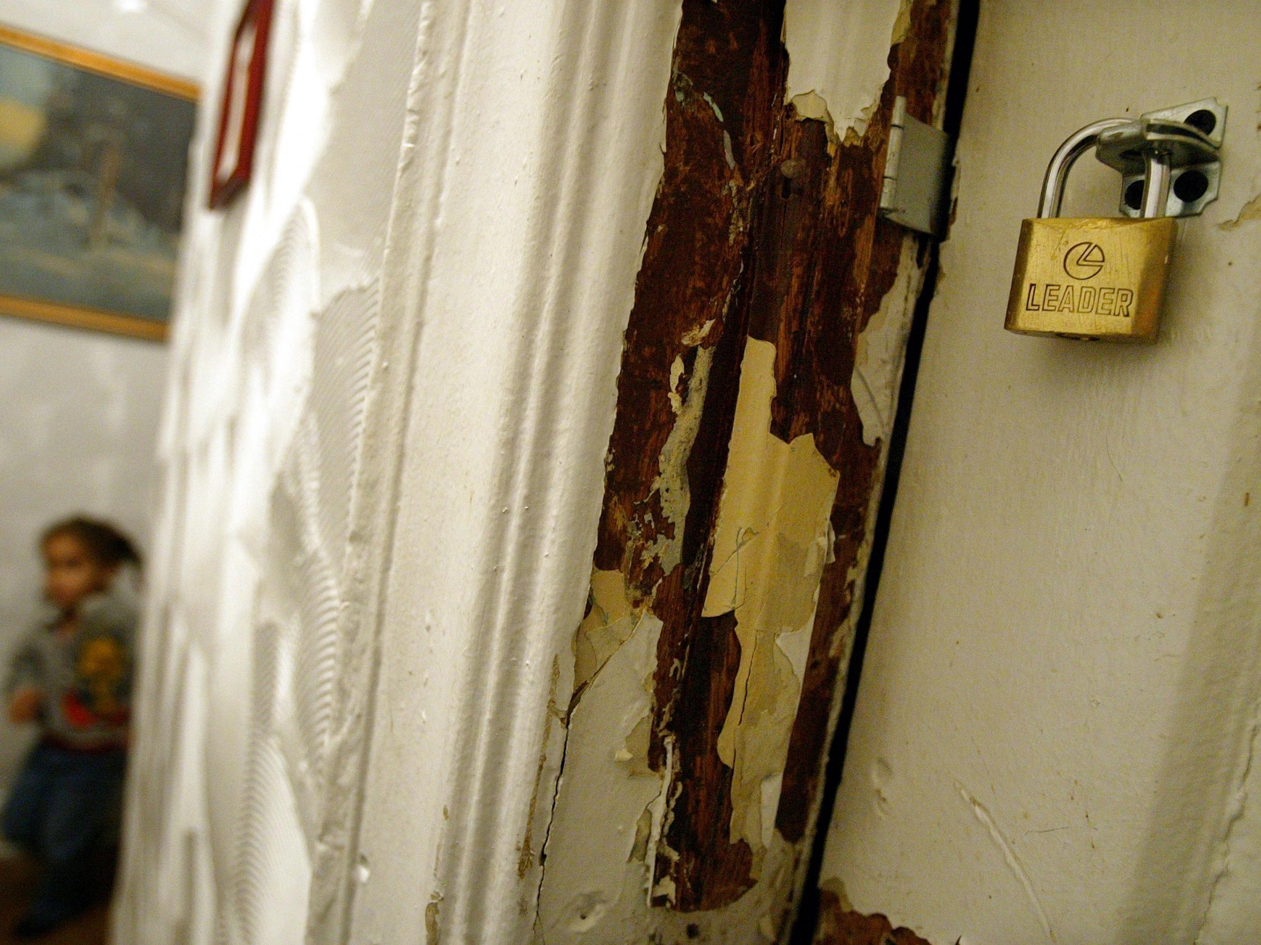 Lead paint peels off the wall of an apartment in New York City